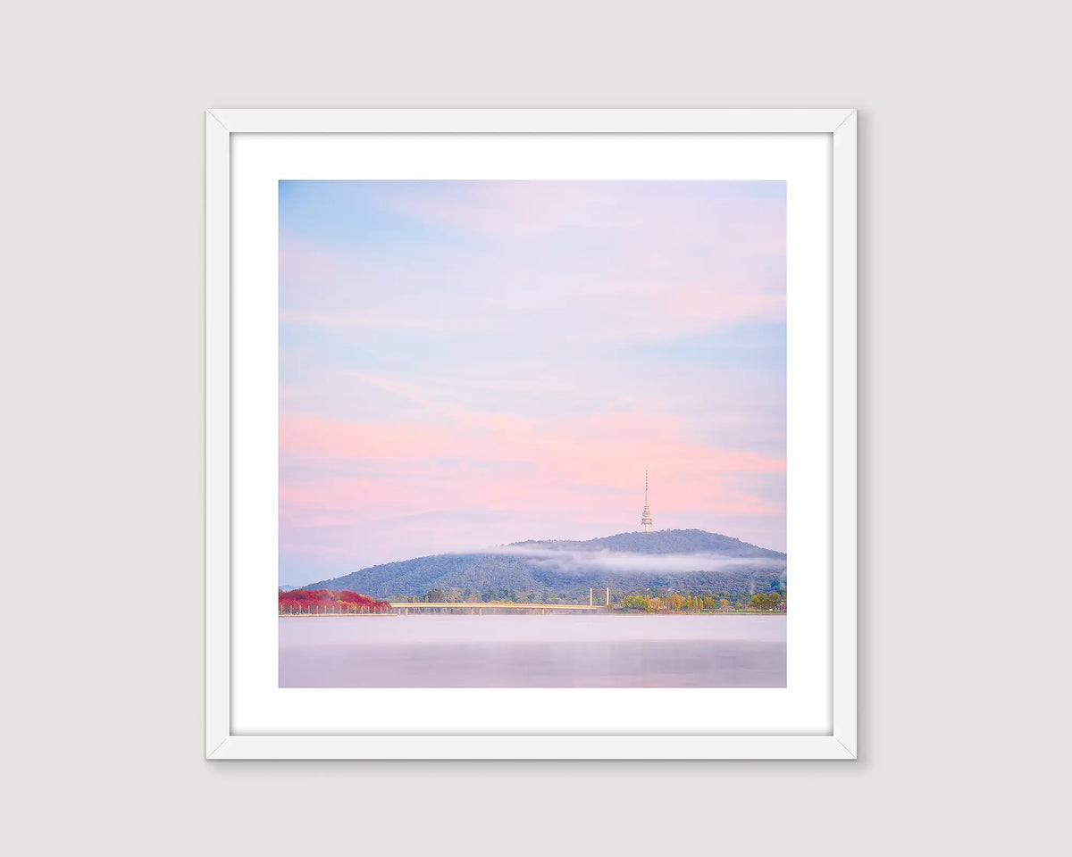 Framed photograph of a fog at sunrise over Lake Burley Griffin with views of red autumn trees and Black Mountain. 