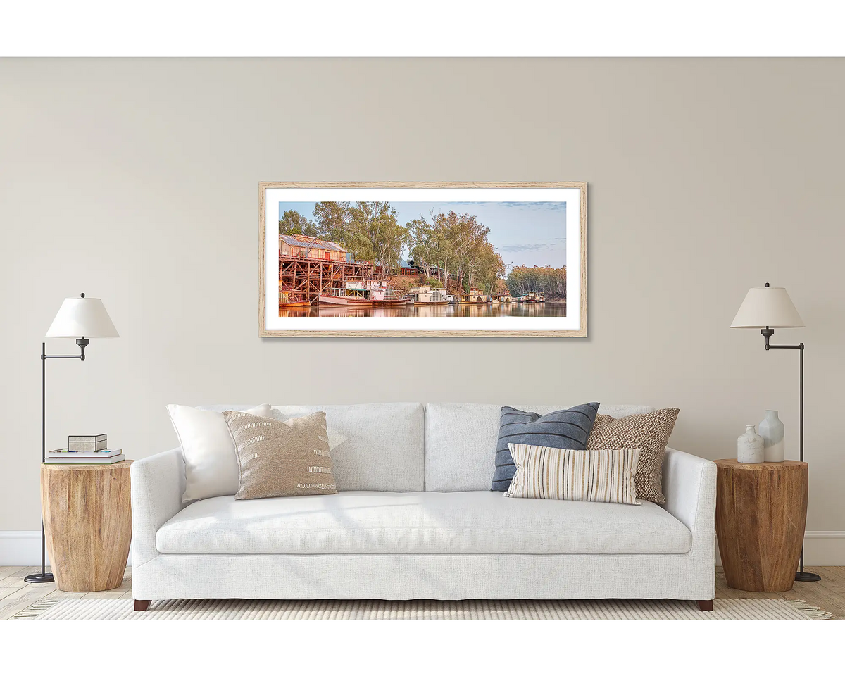 Echuca Lineup. Wall art print of wall art print of paddle steamers and Echuca Wharf, framed in a Tasmanian Oak frame, and hung above a couch. 