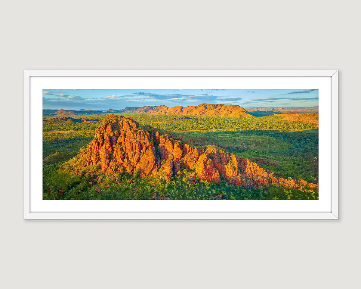 Framed photographic print of a sunset ,over a rock formation nestled amongst green bushland, in the Kimberley.
