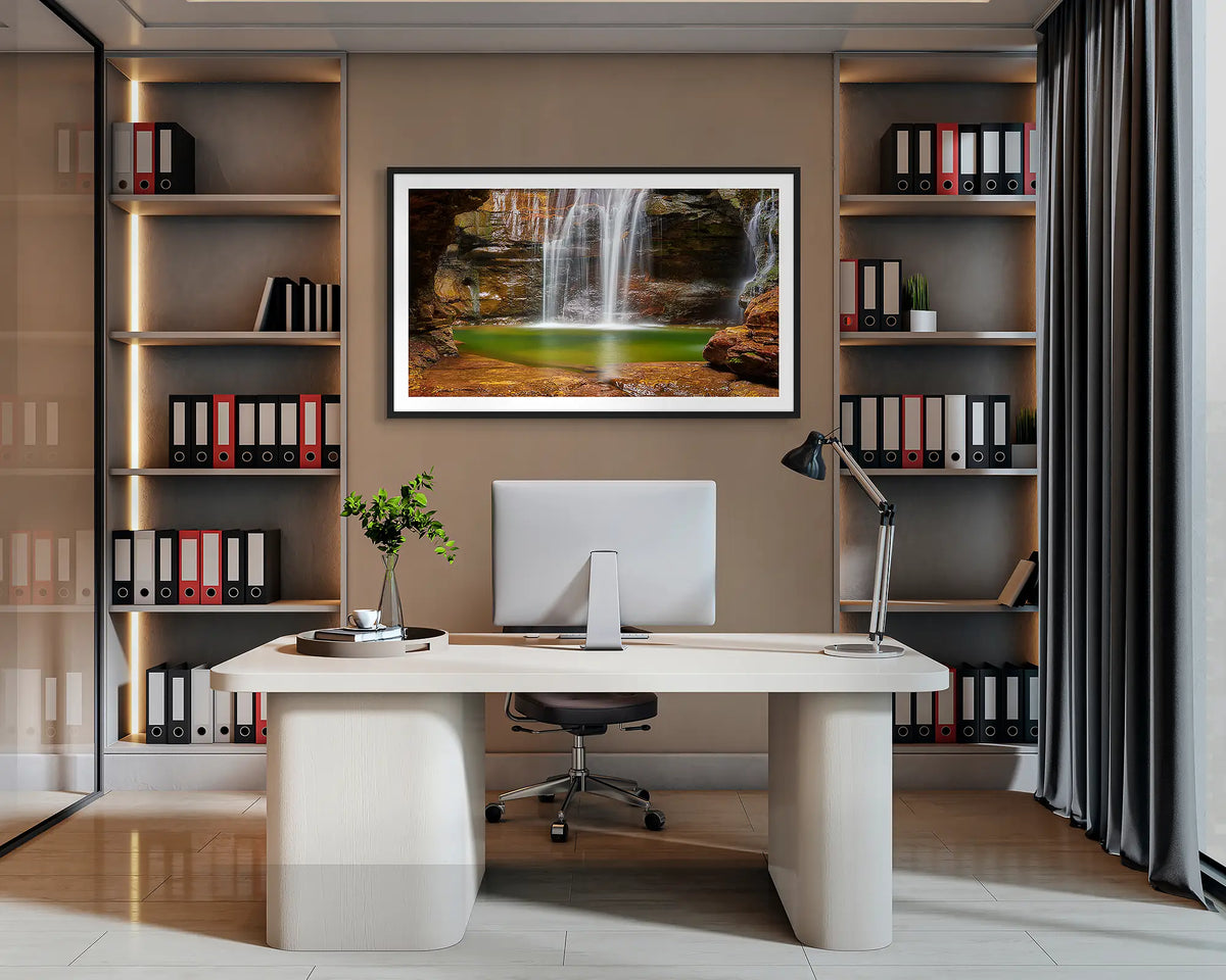 Empress Waters. Wall art print of Empress Falls, Blue Mountains, with a black frame, hanging behind a desk in a corporate office. 