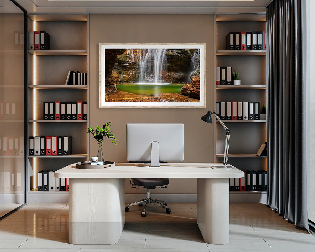 Empress Waters. Wall art print of Empress Falls, Blue Mountains, with a Tasmanian Oak frame, hanging behind a desk in a corporate office. 