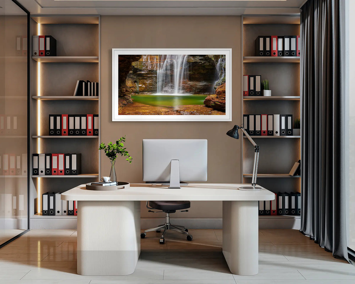 Empress Waters. Wall art print of Empress Falls, Blue Mountains, with a white frame, hanging behind a desk in a corporate office. 