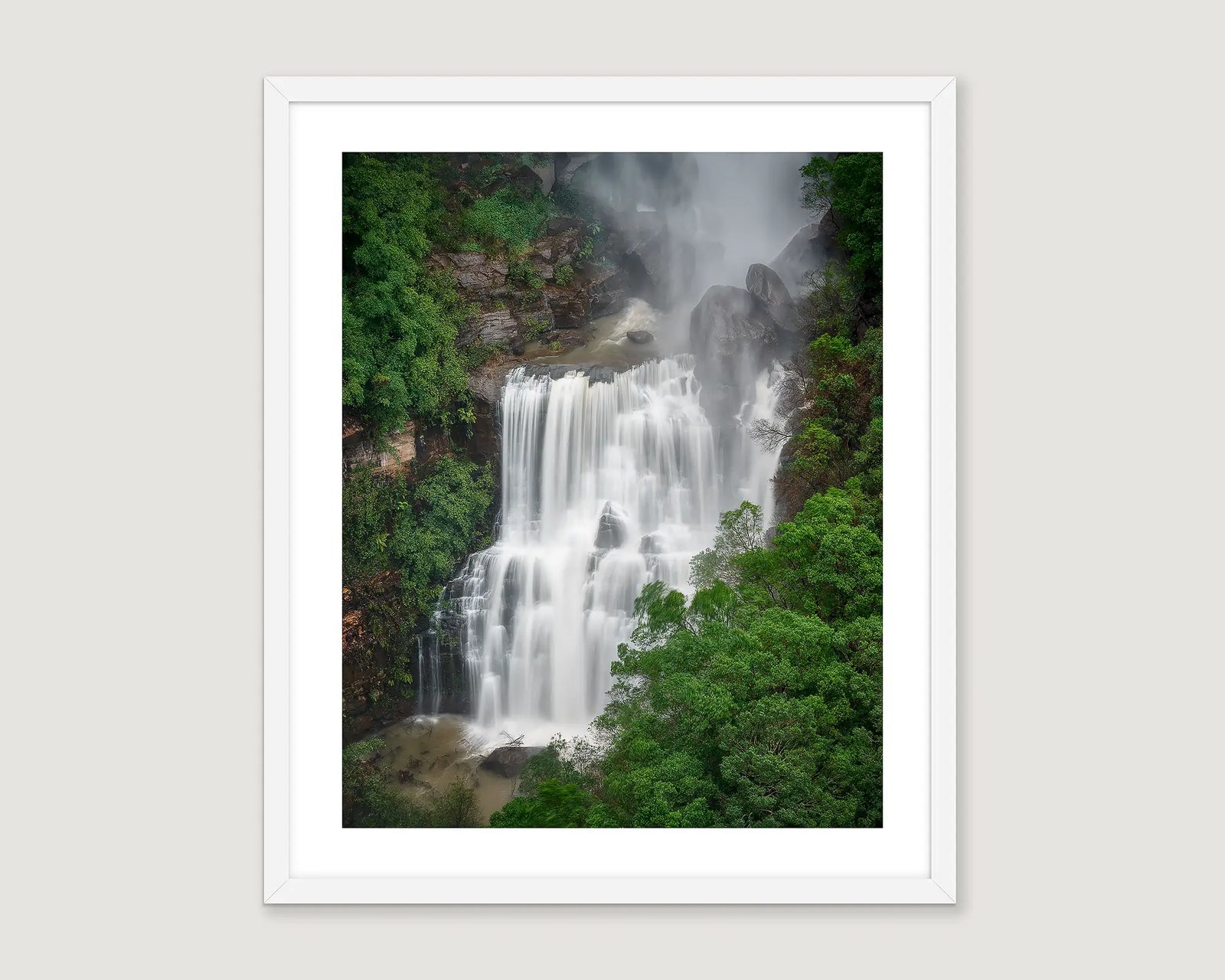 Framed wall art print of water crashing down Fitzroy Falls, throwing mist into the surrounding bush. 
