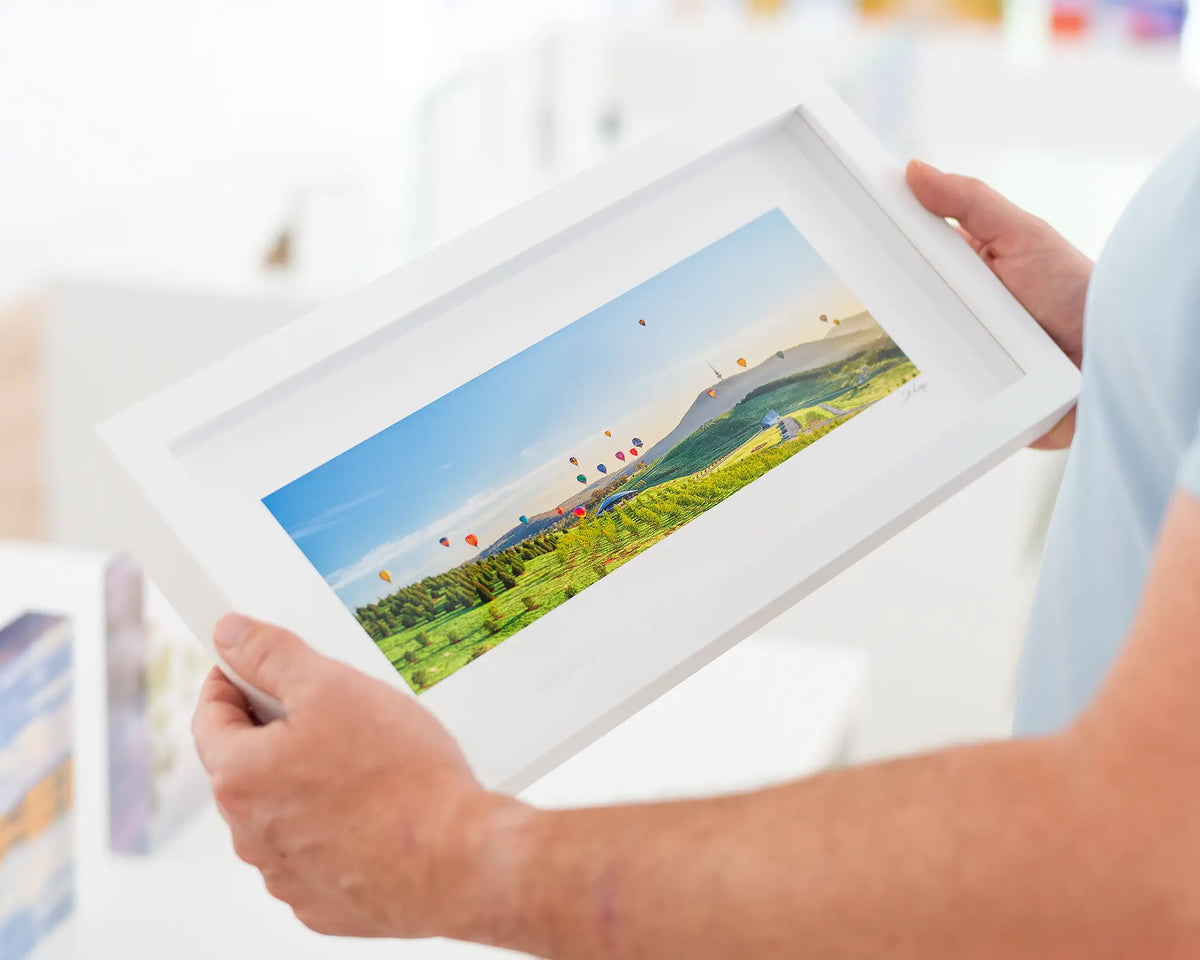 Enlighten - Wall art print of balloons at sunrise over the National Arboretum framed in small white frame.