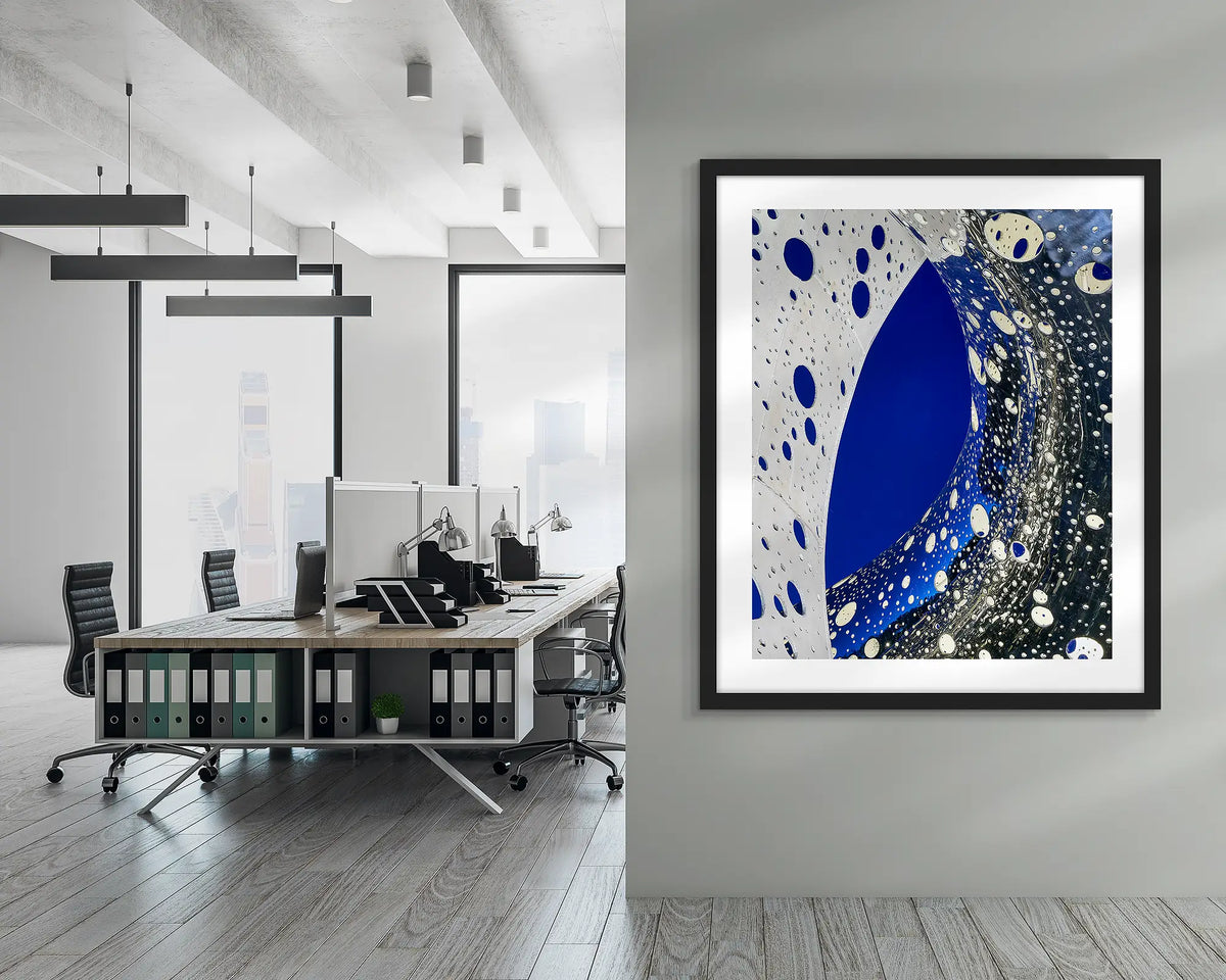 Entwine. Wall art print of the Ouroboros sculpture, framed in a black frame, and hung in a corporate office hallway. 