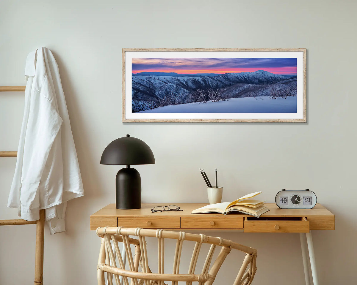 Evening Glory. Winter snow sunrise wall art print with timber frame, above a small table.