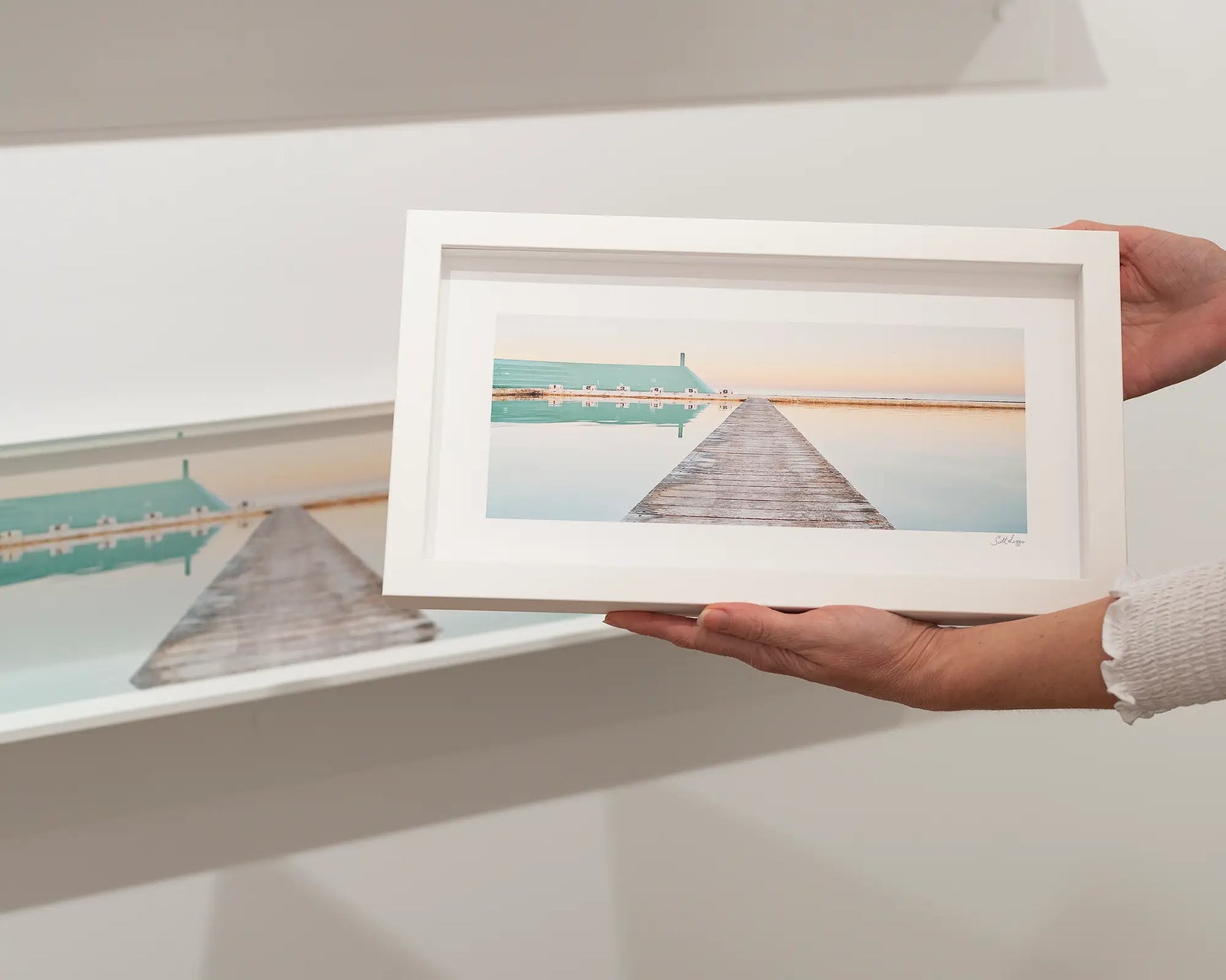 Framed photographic print of still water and a jetty at Newcastle Ocean Baths at sunrise.