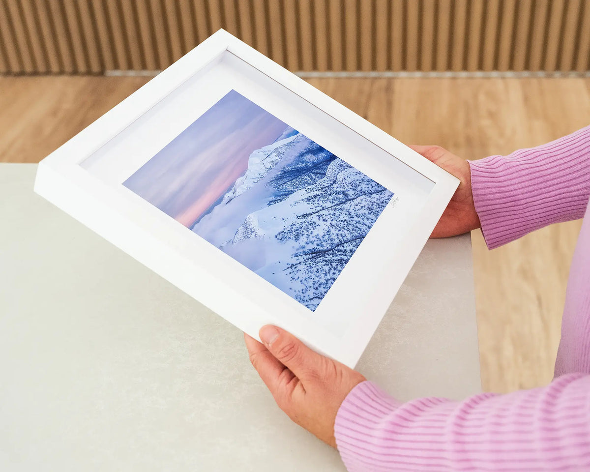Feathertop Dusk. Small framed print of snow covered mountains at dusk, Mount Feathertop Victoria, held in hands.