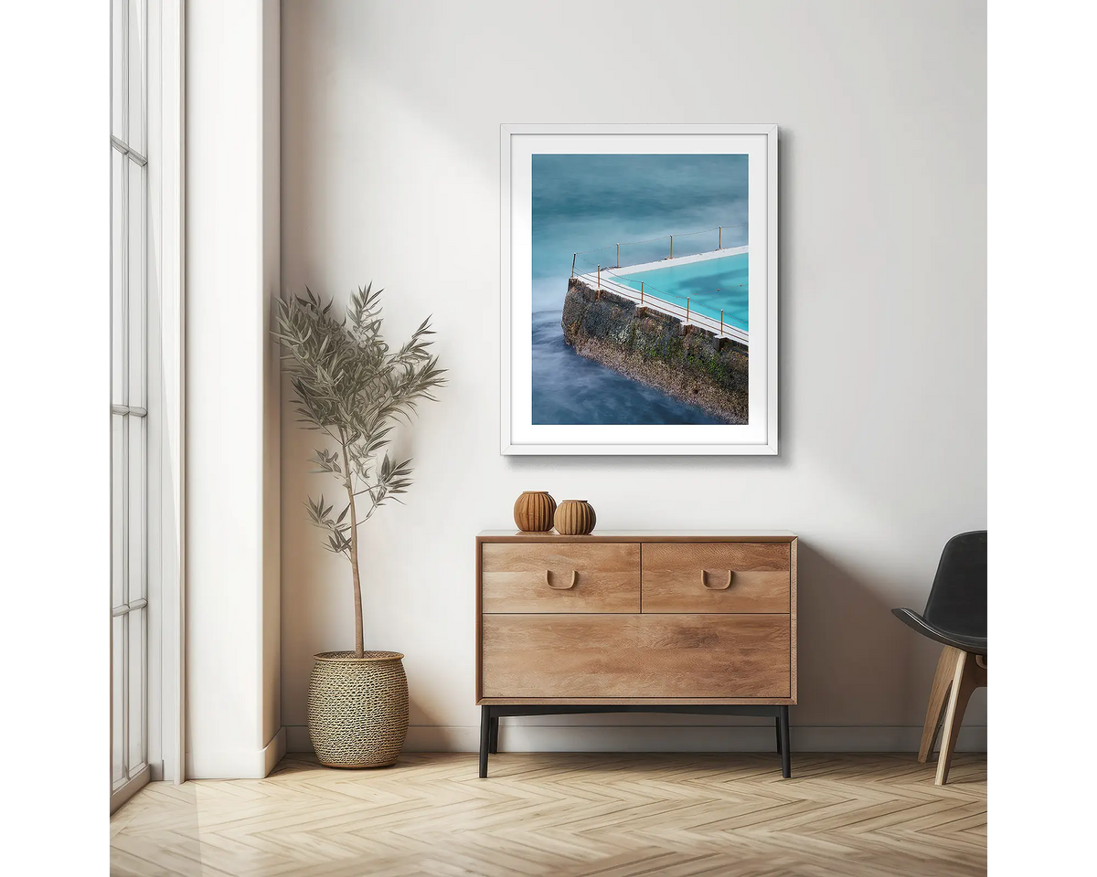Fenced In. Bondi Icebergs photographic wall art print with a white frame, hung in a scandi hallway. 