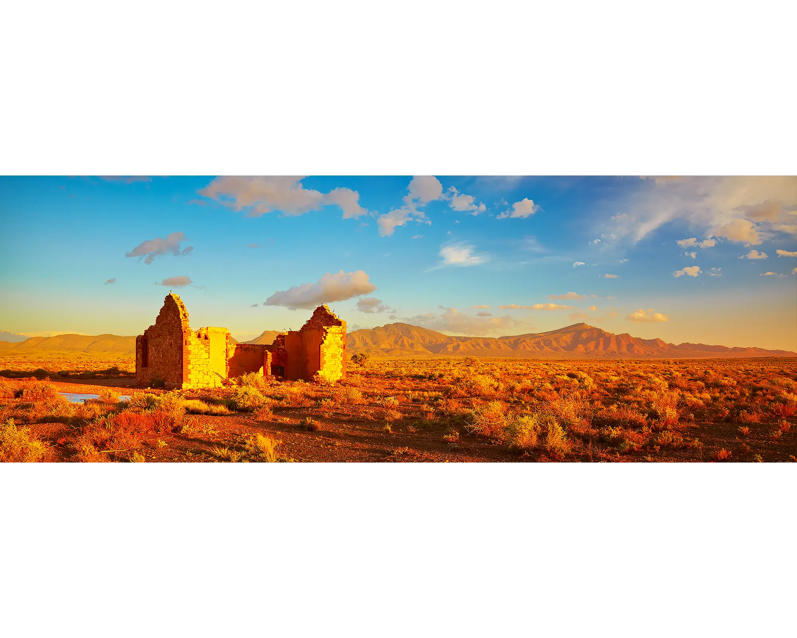 Ruins of old houses with Wilpena Pound in the backrground, Flinders Ranges, SA. 