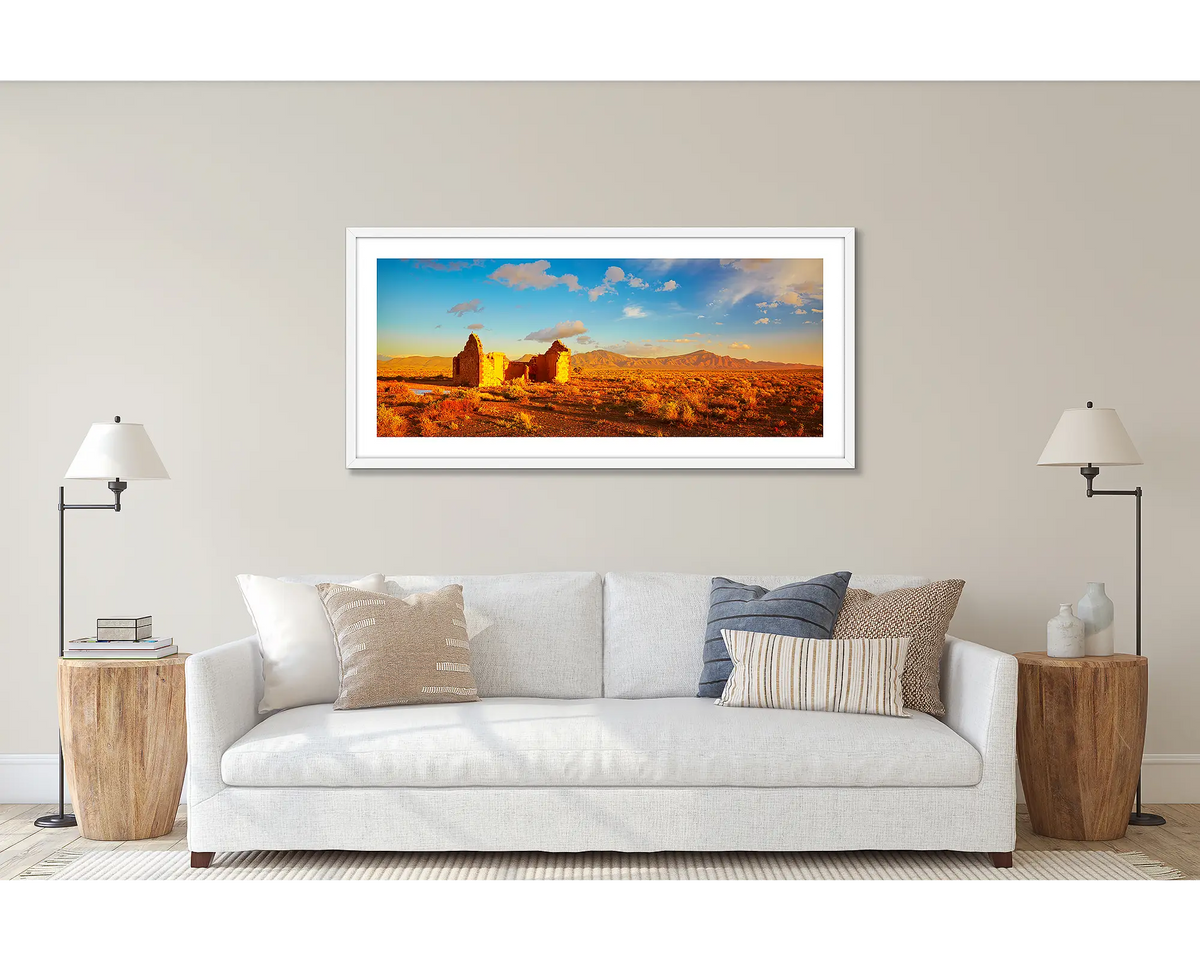 Flinders Ruins. Wall art print of a sunset in the Flinders Ranges, framed with a white frame and hung above a couch. 