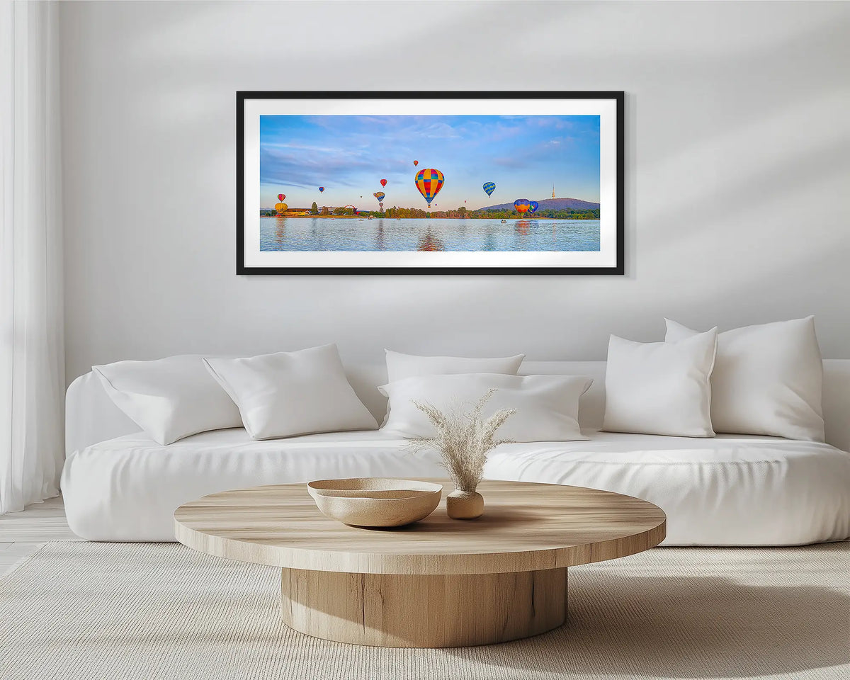 Floating. Black framed wall art print of Canberra hot air balloons, hung in a scandi-themed lounge room.