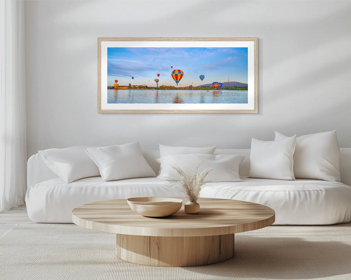 Floating. Timber framed wall art print of Canberra hot air balloons, hung in a scandi-themed lounge room.