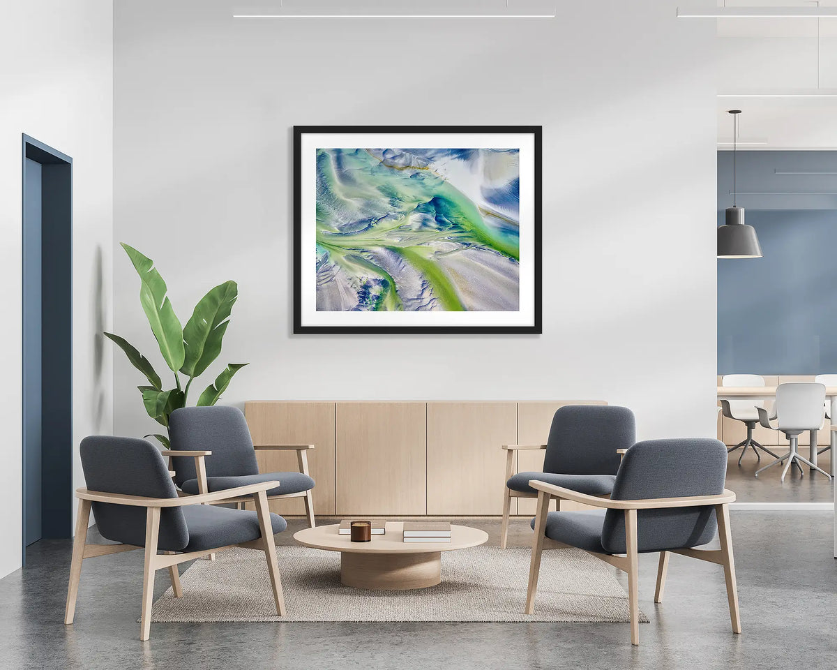 Flow. Aerial abstract wall art print with a black frame, hung on the wall of a waiting area.