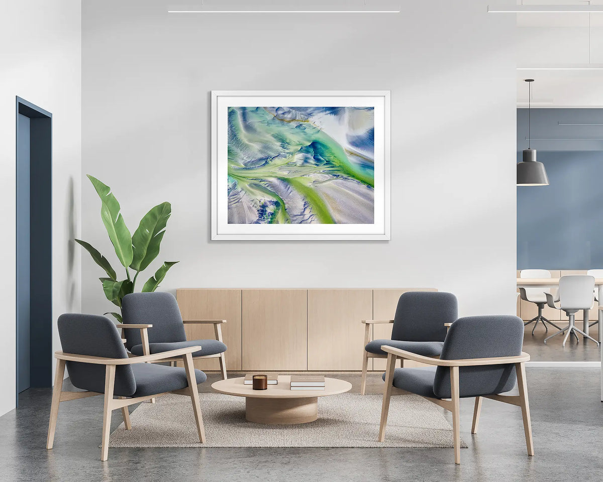 Flow. Aerial abstract wall art print with a white frame, hung on the wall of a waiting area.
