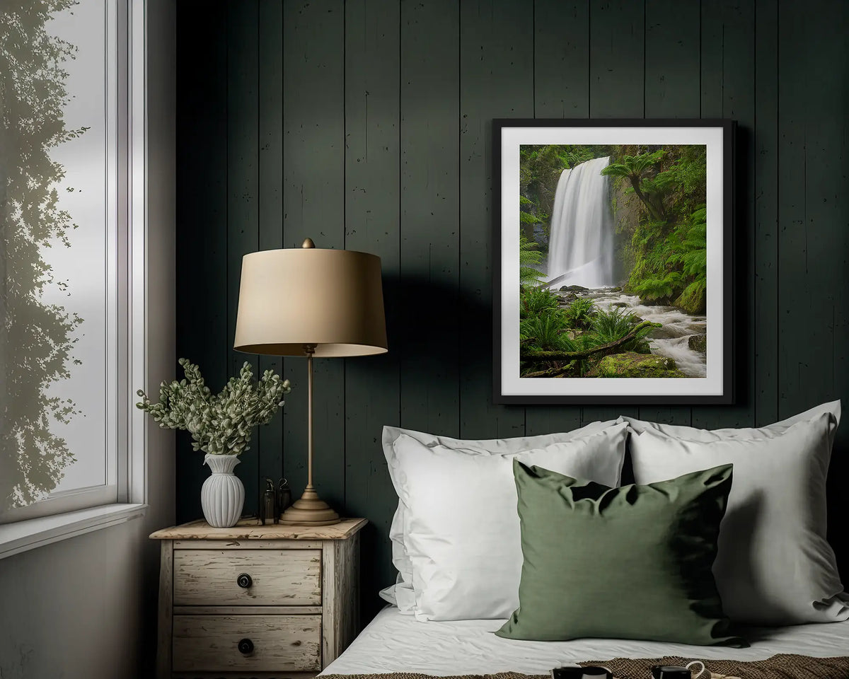 Forest Veil. Wall art print of Hopetoun Falls, with a black frame, hung above a bed. 