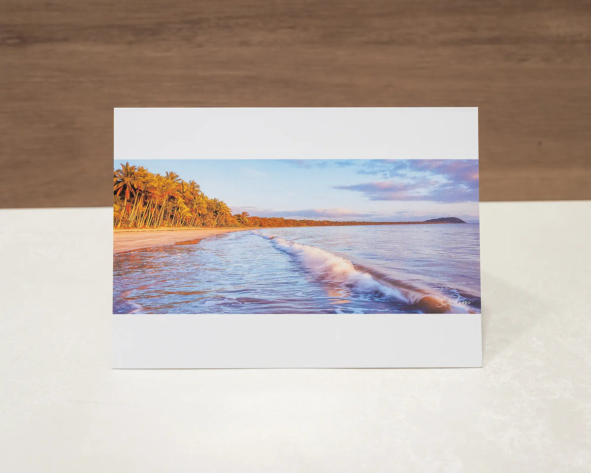 Four Mile Sunrise greeting card of sunrise over Four Mile Beach, Port Douglas, sitting on desk.