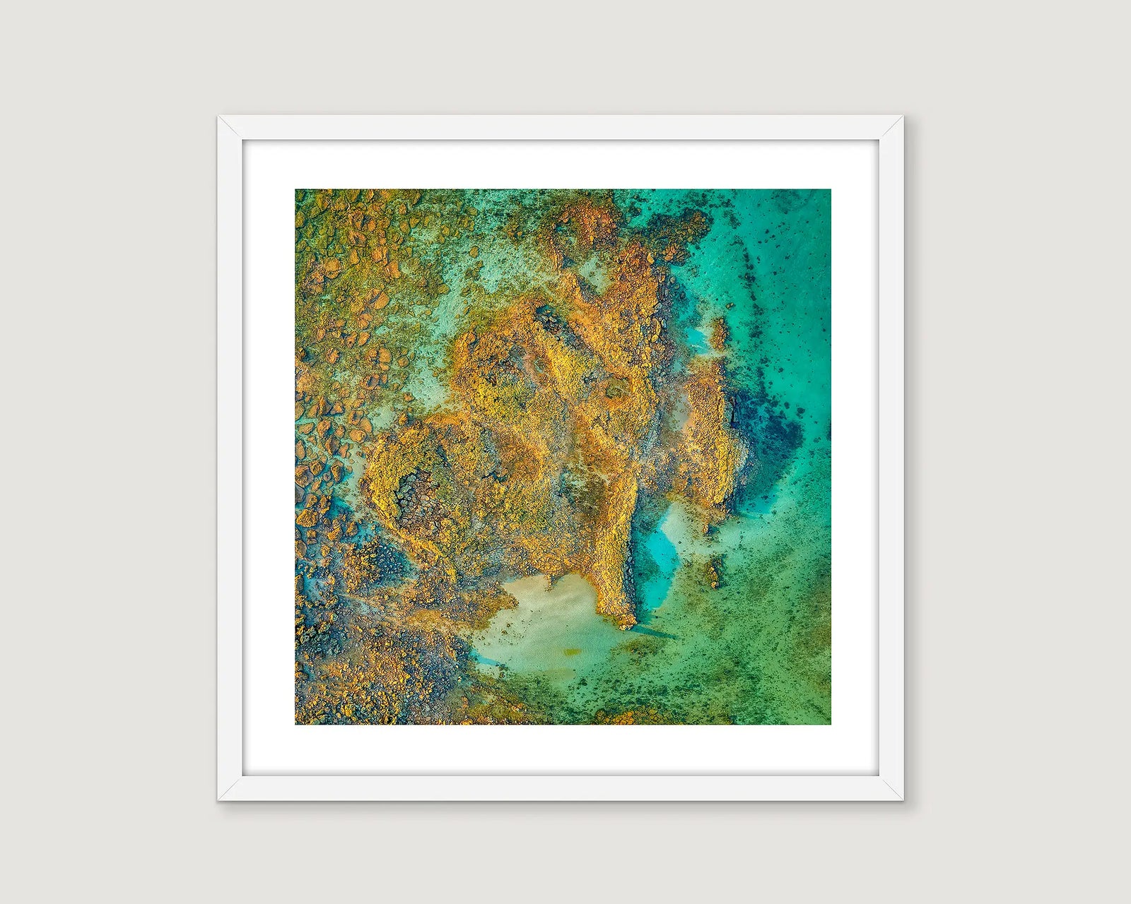 Framed coastal wall art print of an aerial view of a rock formation jutting out a turquiose ocean at James Price Point. 