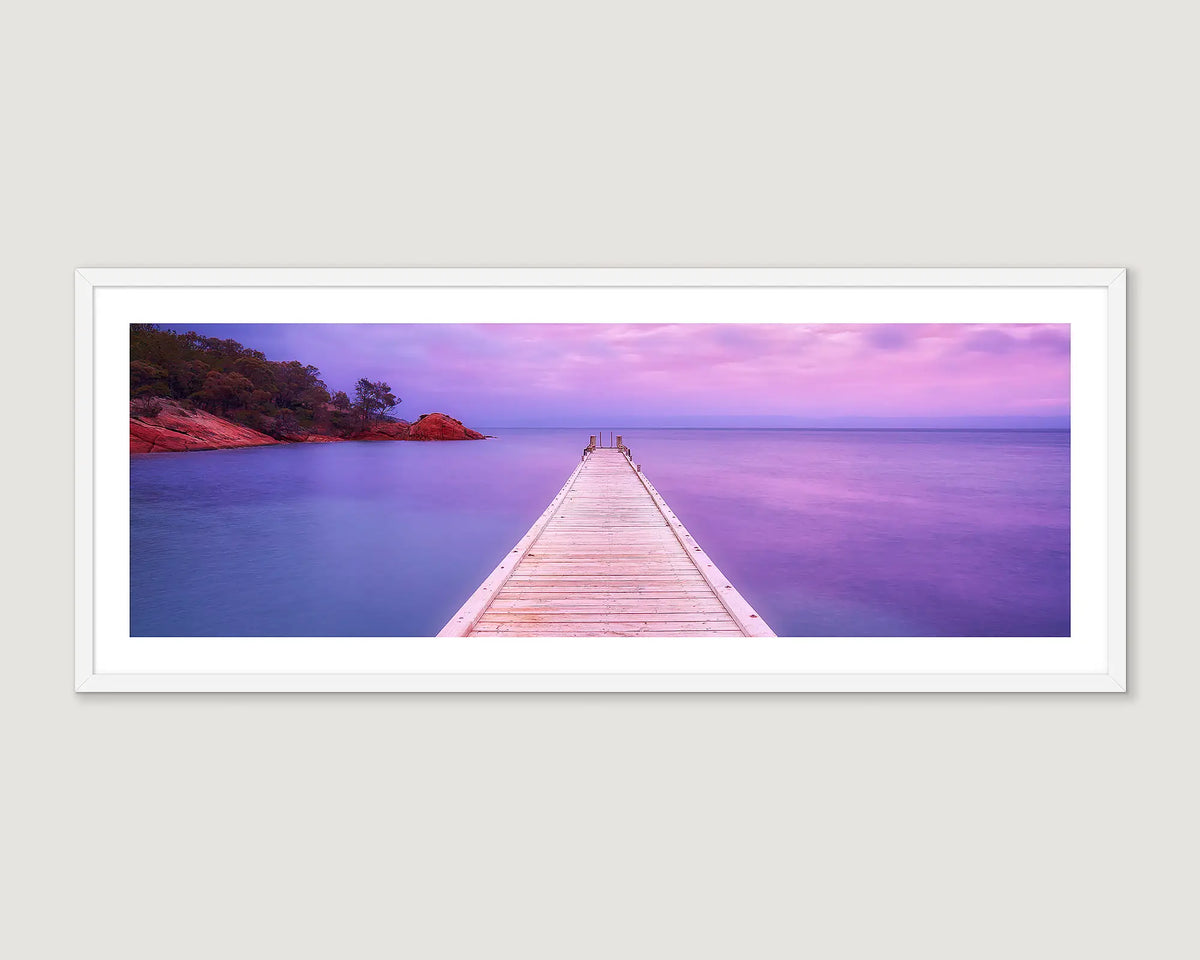 Framed coastal artwork of a wooden pier at sunrise at Oyster Bay. 