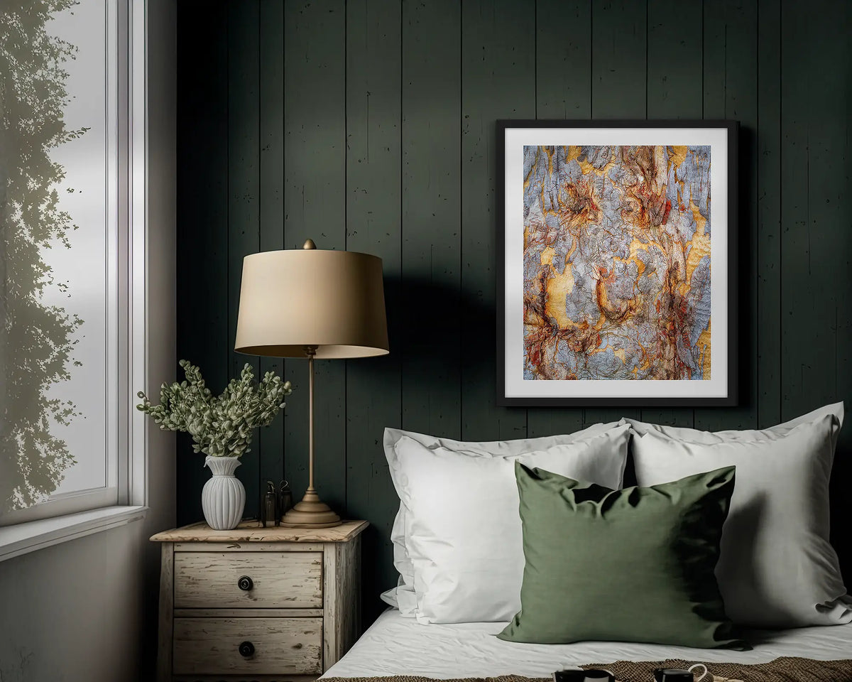 Funny Faces. Abstract wall art print of gum tree bark on Mount Ainslie, with a black frame hung above a bed. 