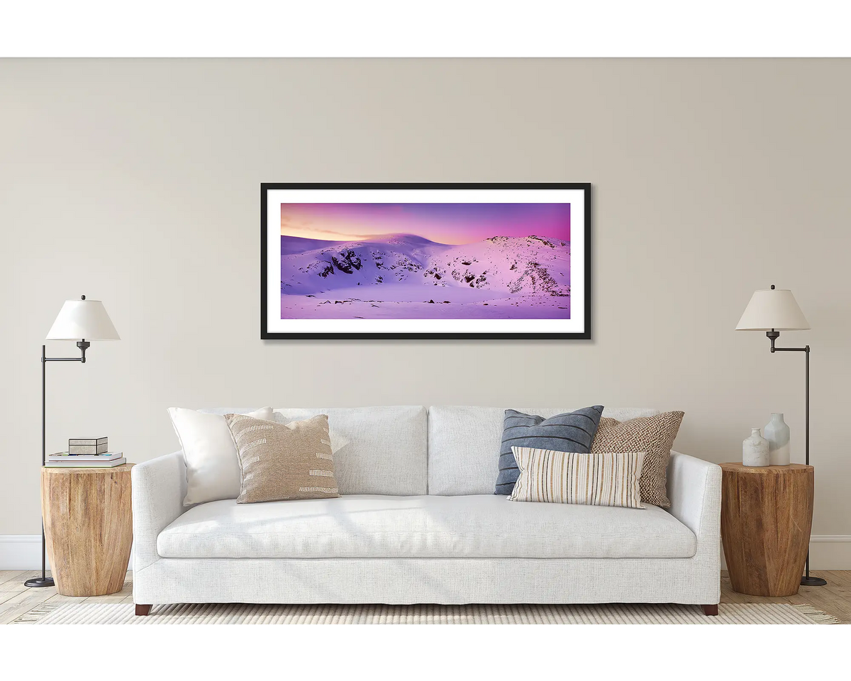 Glacial Landscape. Wall art print of a sunset over Blue Lake, Kosciuszko National Park, framed with a black frame and hung above a couch. 