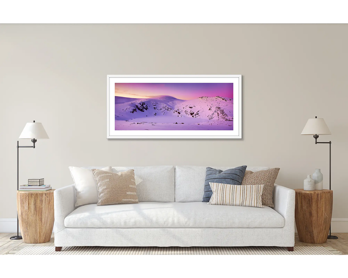 Glacial Landscape. Wall art print of a sunset over Blue Lake, Kosciuszko National Park, framed with a white frame and hung above a couch. 