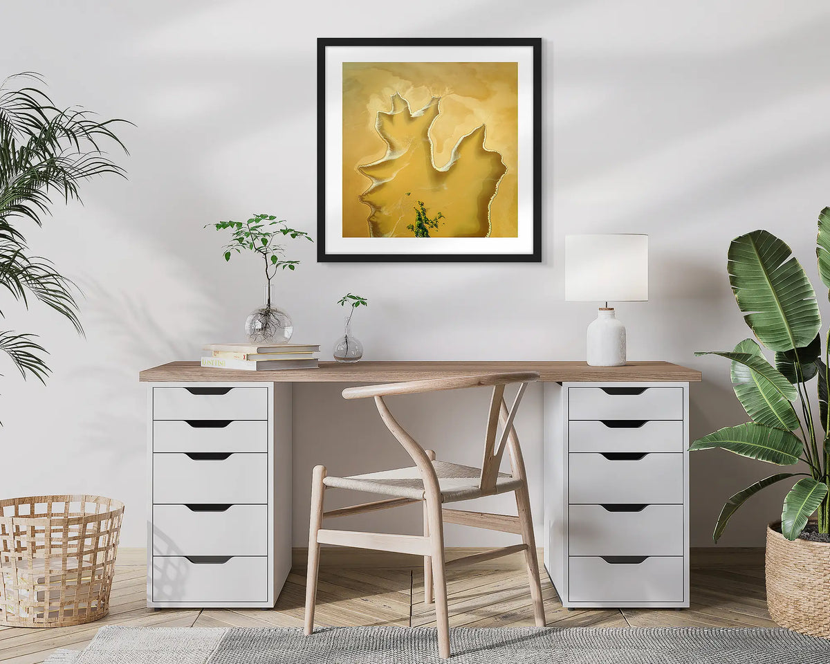 Golden Derby. Aerial, abstract photographic wall art print with a black frame, hung in a home office. 