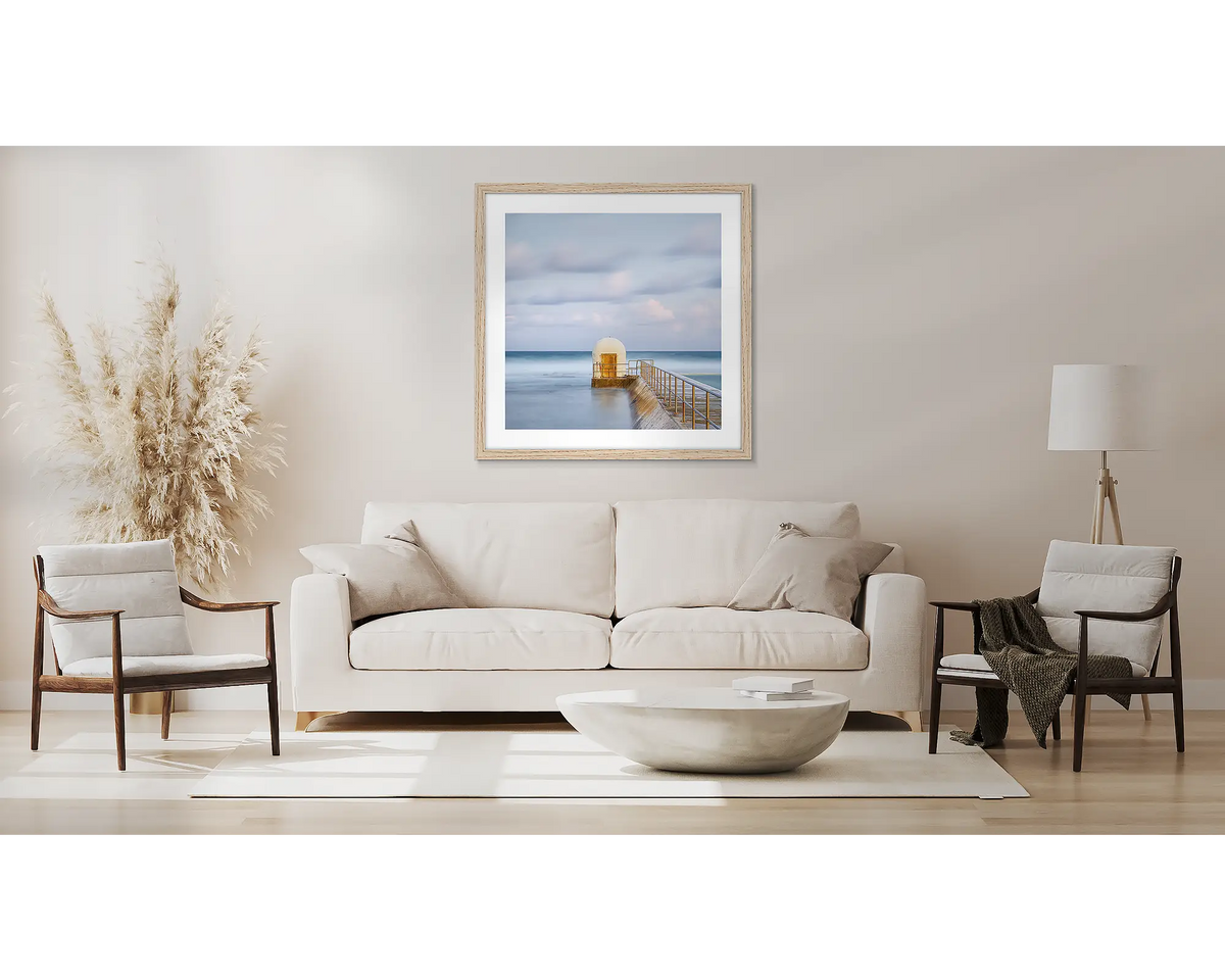 Golden Door. Wall art print with timber frame of the pumphouse at Merewether Baths Newcastle, hung above a couch.