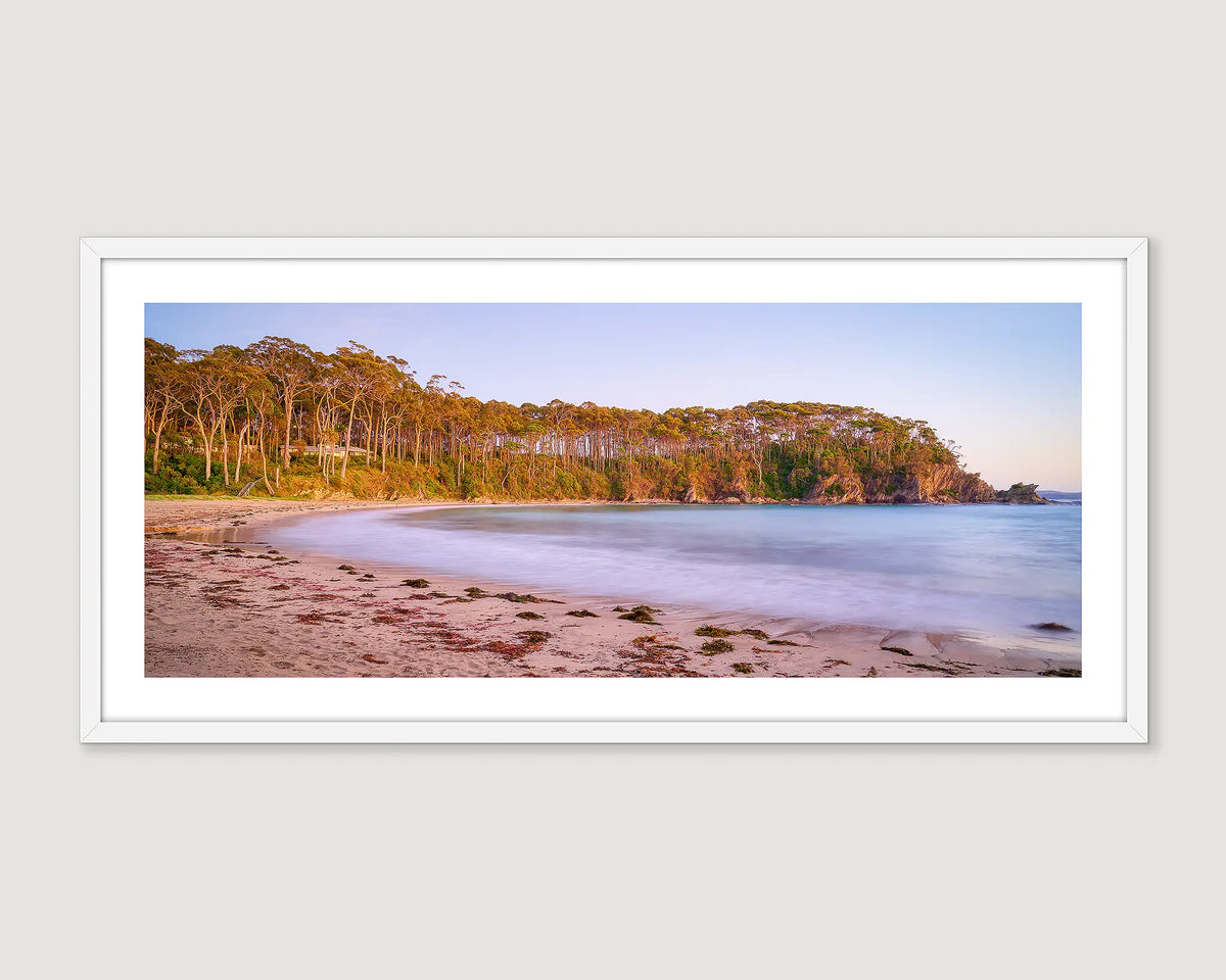 Framed artwork of a coastal scene with calm water and native bushland at Llilli Pilli. 