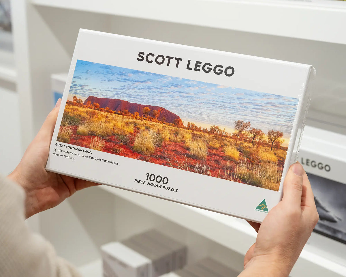 Great Southern Land 1000 piece jigsaw puzzle being held in front of other puzzles.
