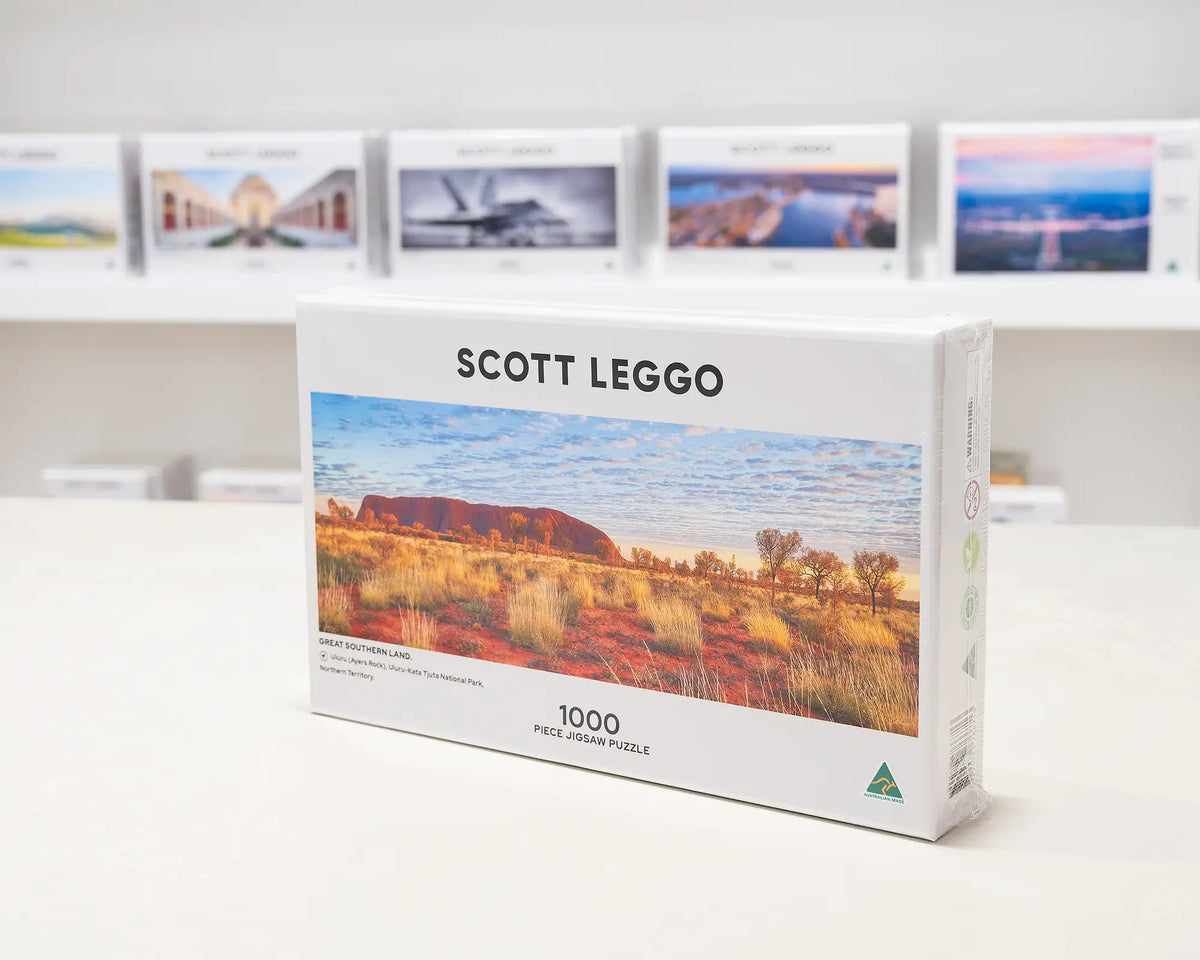 Great Southern Land 1000 piece jigsaw puzzle sitting on desk in front of other puzzles.