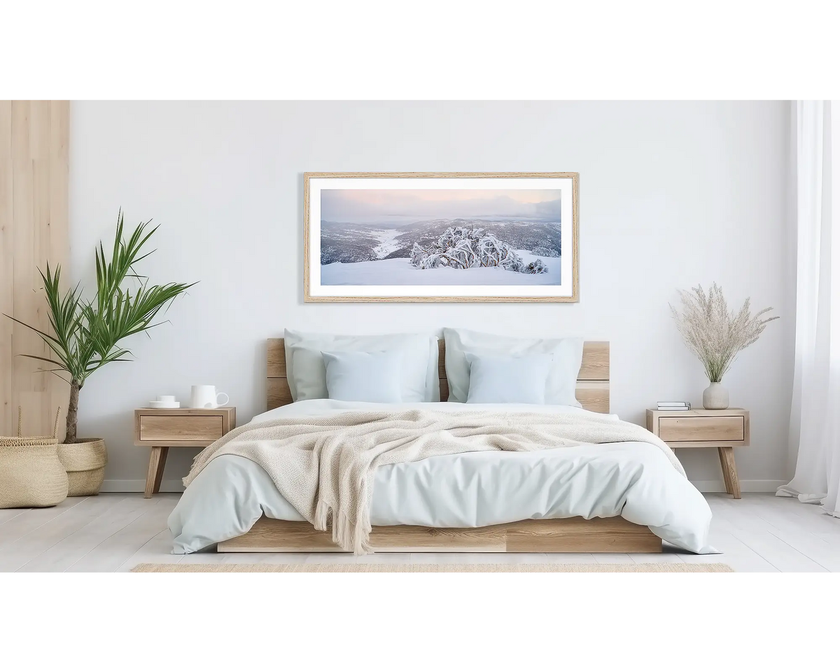 Guardian of the Valley. Wall art print of a snow gum overlooking a snow covered valley, framed in a timber frame and hung above a bed.