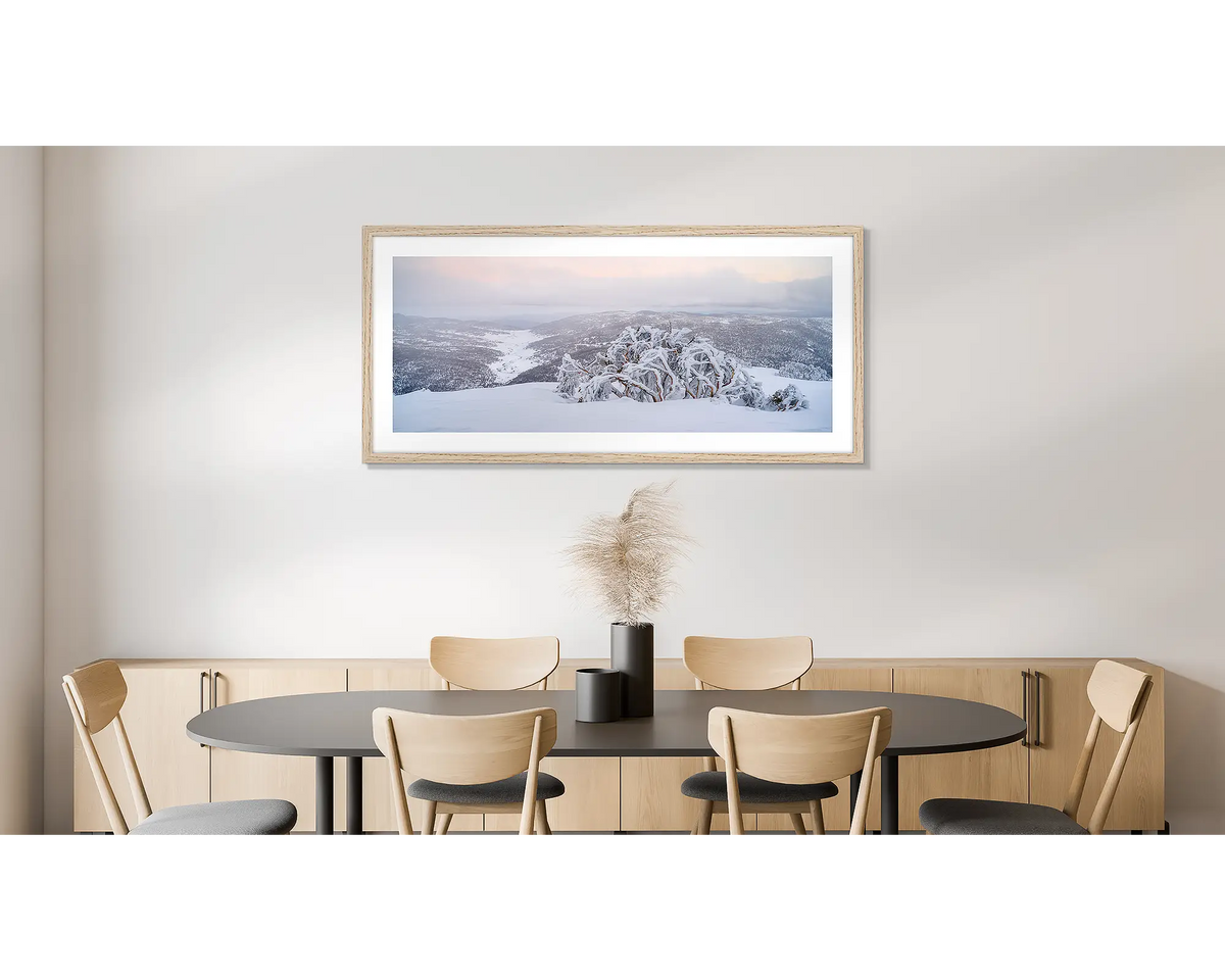 Guardian of the Valley. Wall art print of a snow gum overlooking a snow covered valley, framed in a timber frame and hung on a dining room wall. 