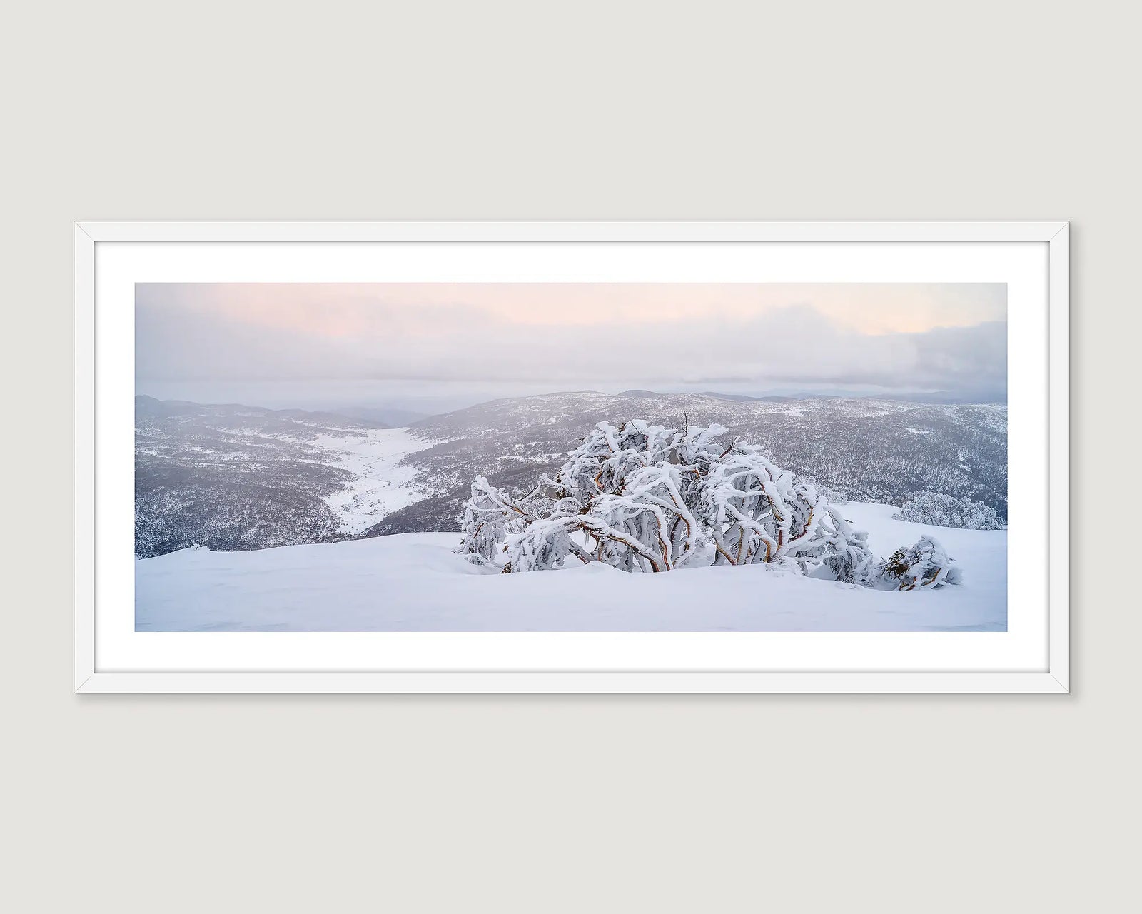 Framed wall art print of snow gum laden with ice and buried in snow with views of the Thredbo valley.