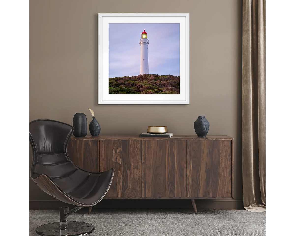Guiding Light. Wall art print of Split Point Lighthouse, framed with a white frame and hung in a lounge room. 