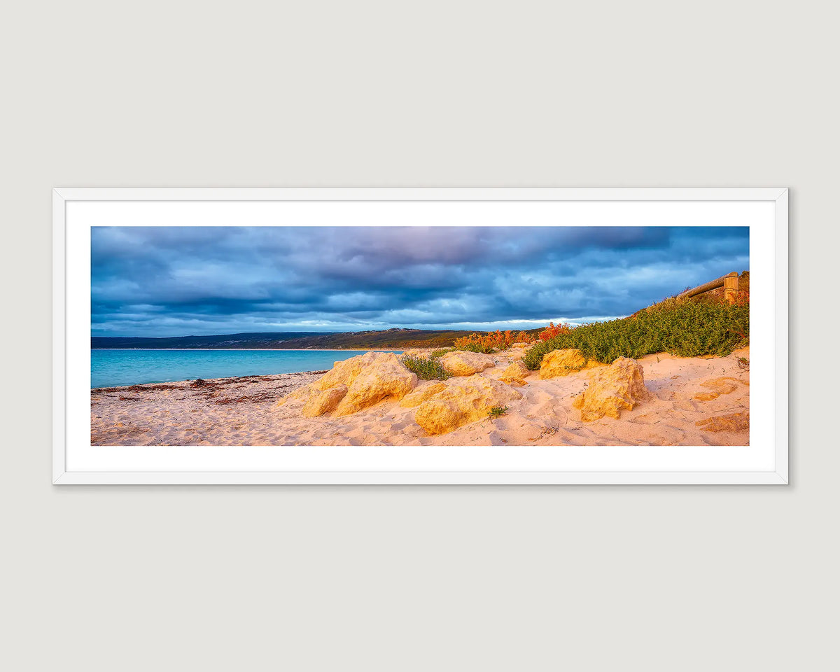 Framed wall art print of a cloudy sunset at Hamelin Bay with coastal bush and limestone rocks. 