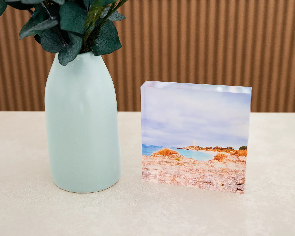 Haven. Acrylic block of Bathurst Lighthouse, Rottnest Island, on desk styled with flower vase.
