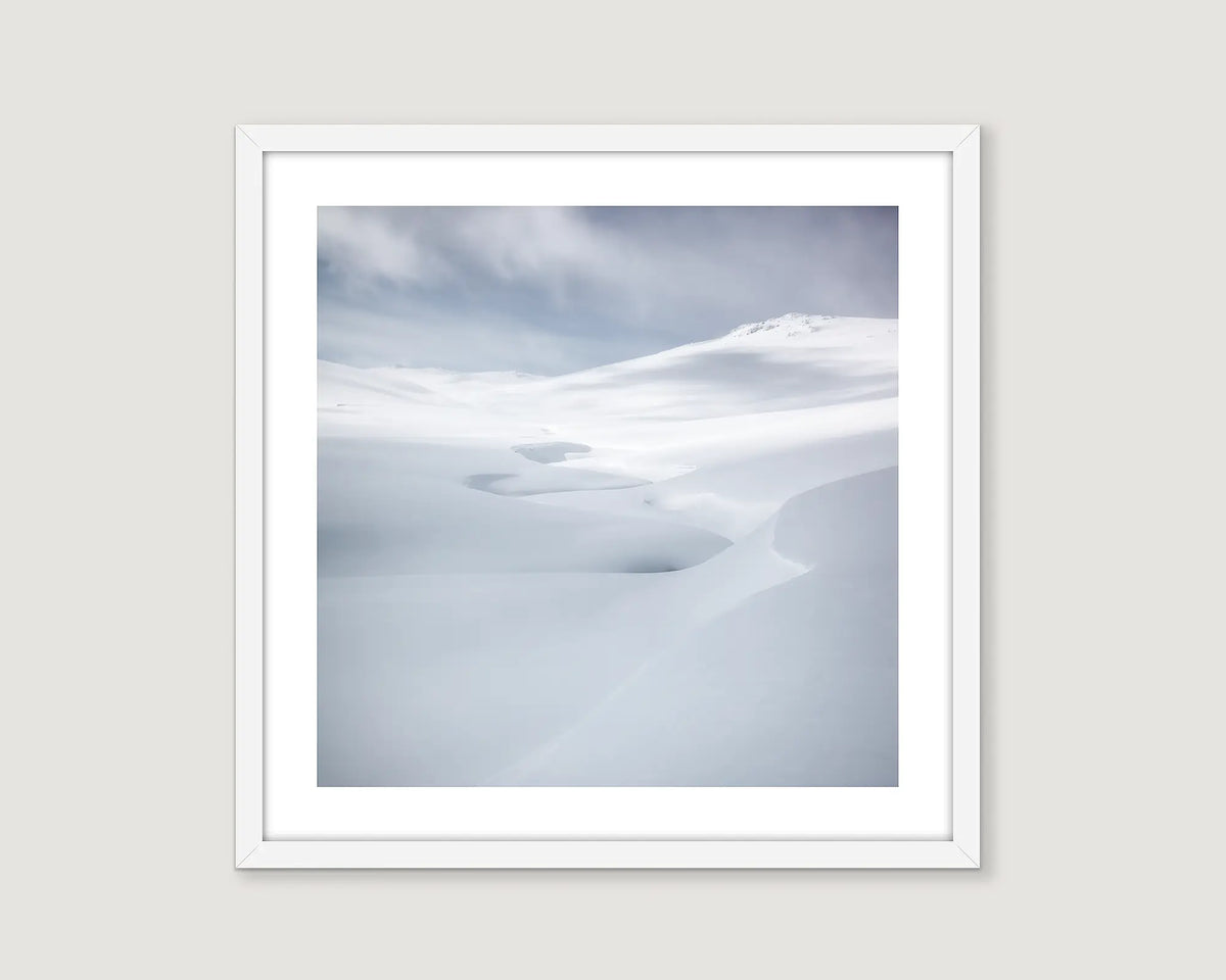 Framed wall art print of grey skies and a creek covered in heavy snow fall in Kosciuszko National Park. 