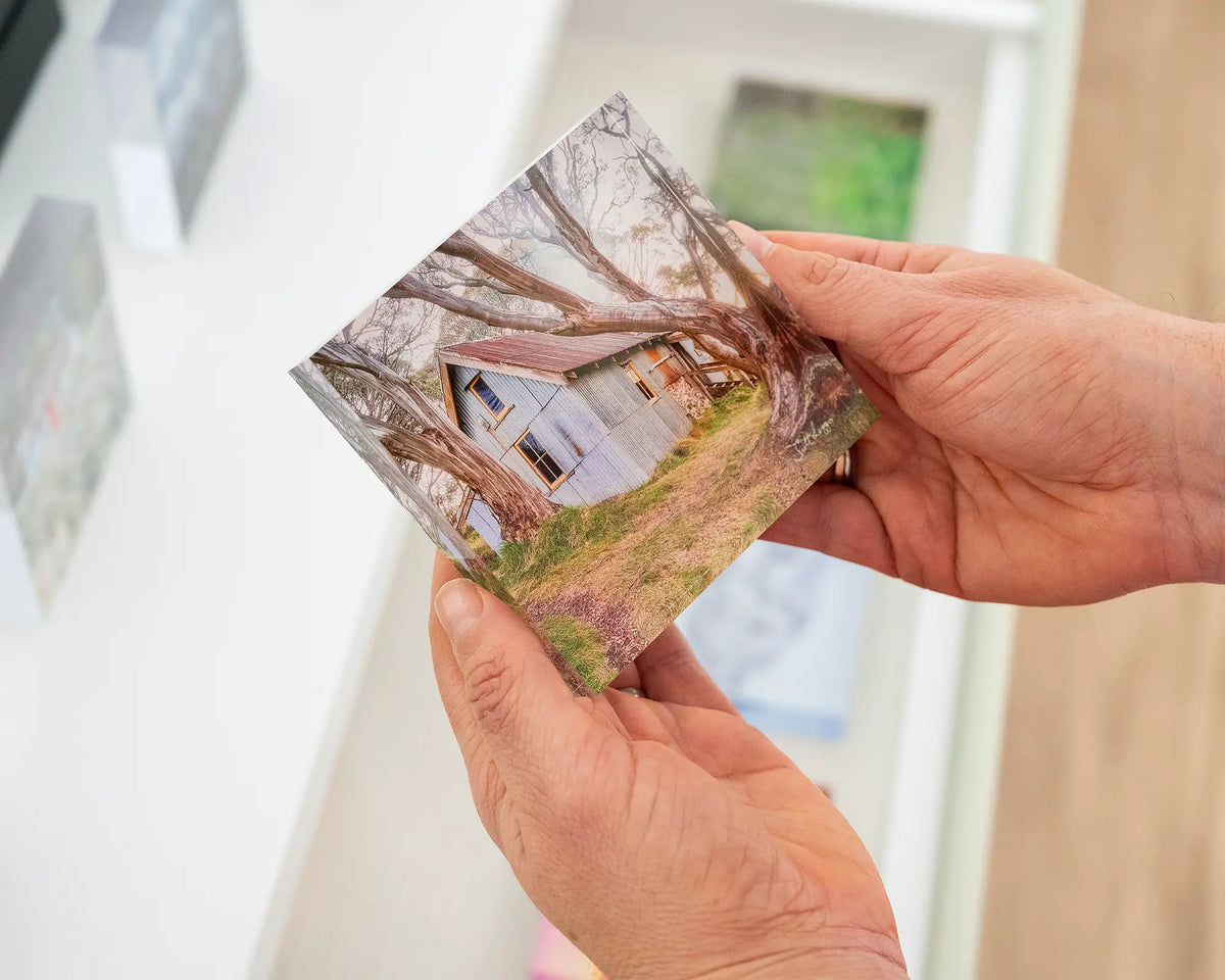 High Country Life. Acrylic block of Cope Hut, Victoria, held in hands.