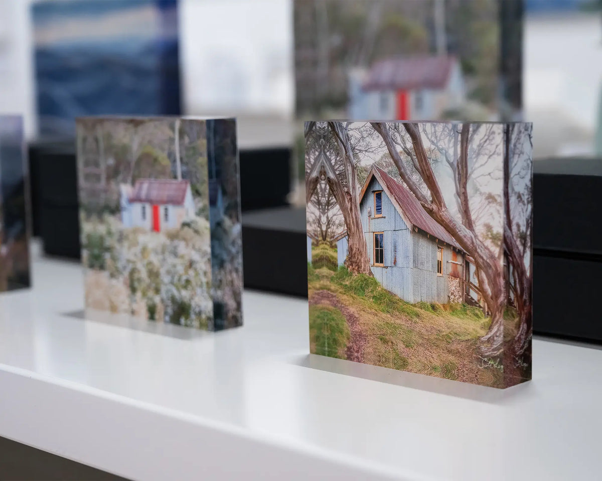 High Country Life. Acrylic block of Cope Hut, Victoria, on display in gallery with more alpine acrylic blocks.