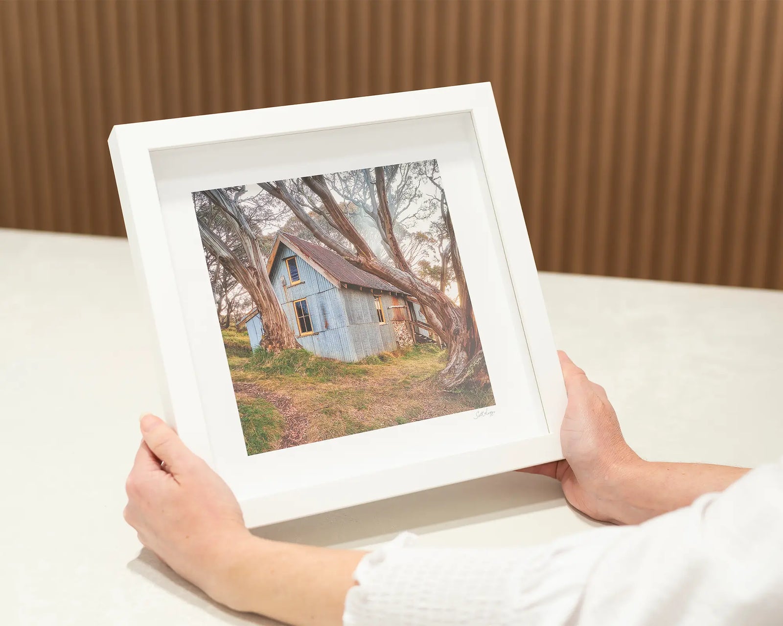 Framed wall art print of Cope Hut nestled among gnarly snow gums on Mount Bogong. 