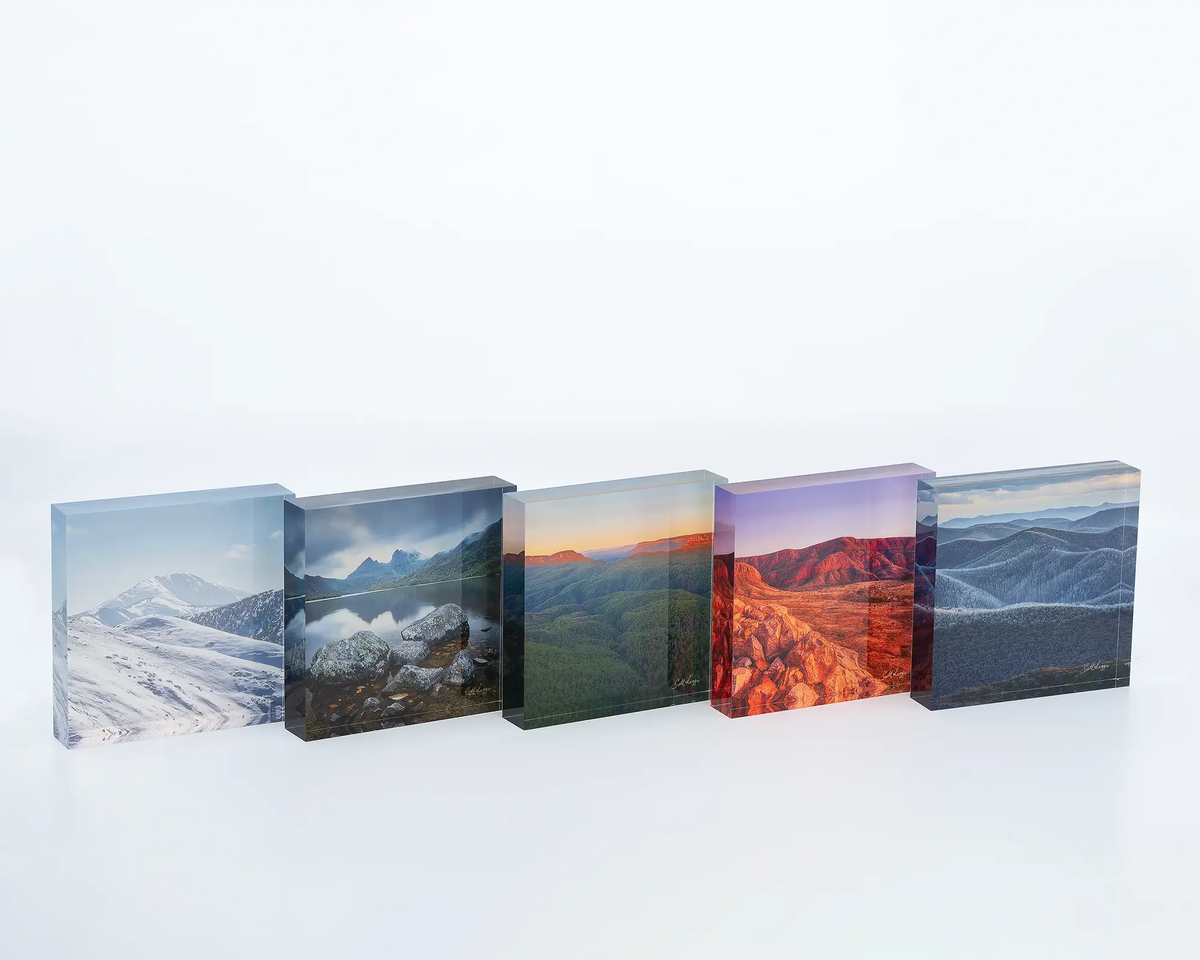 Icon of the Alps acrylic block displayed on a desk with other square acrylic blocks. 