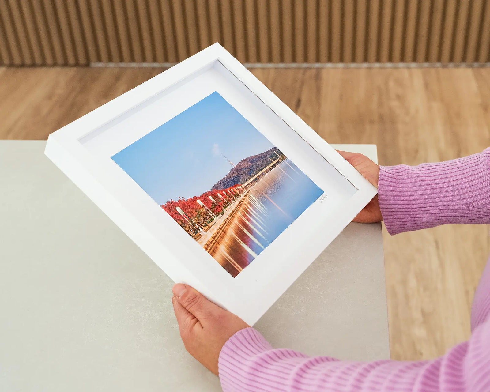 Framed wall art print of trees turning red around Lake Burley Griffin on an autumn morning, with Black Mountain in view. 