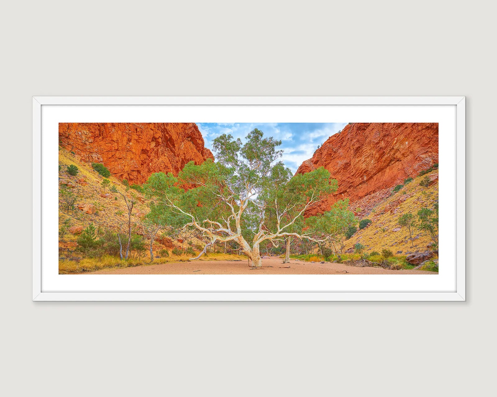 Framed artwork of a landscape with a tree and red rock formations.