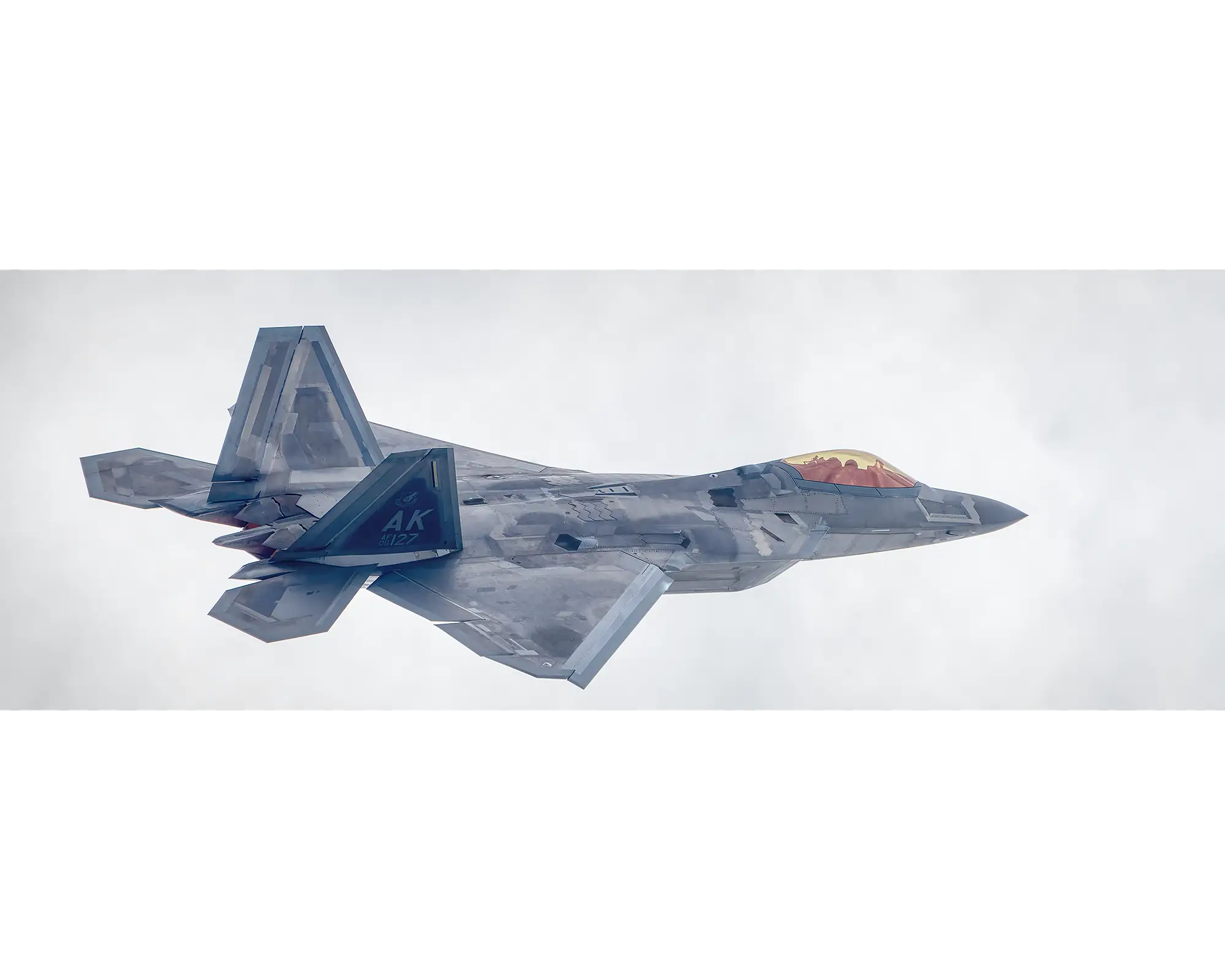 United States Air Force F-22 Raptor flying through clouds. 