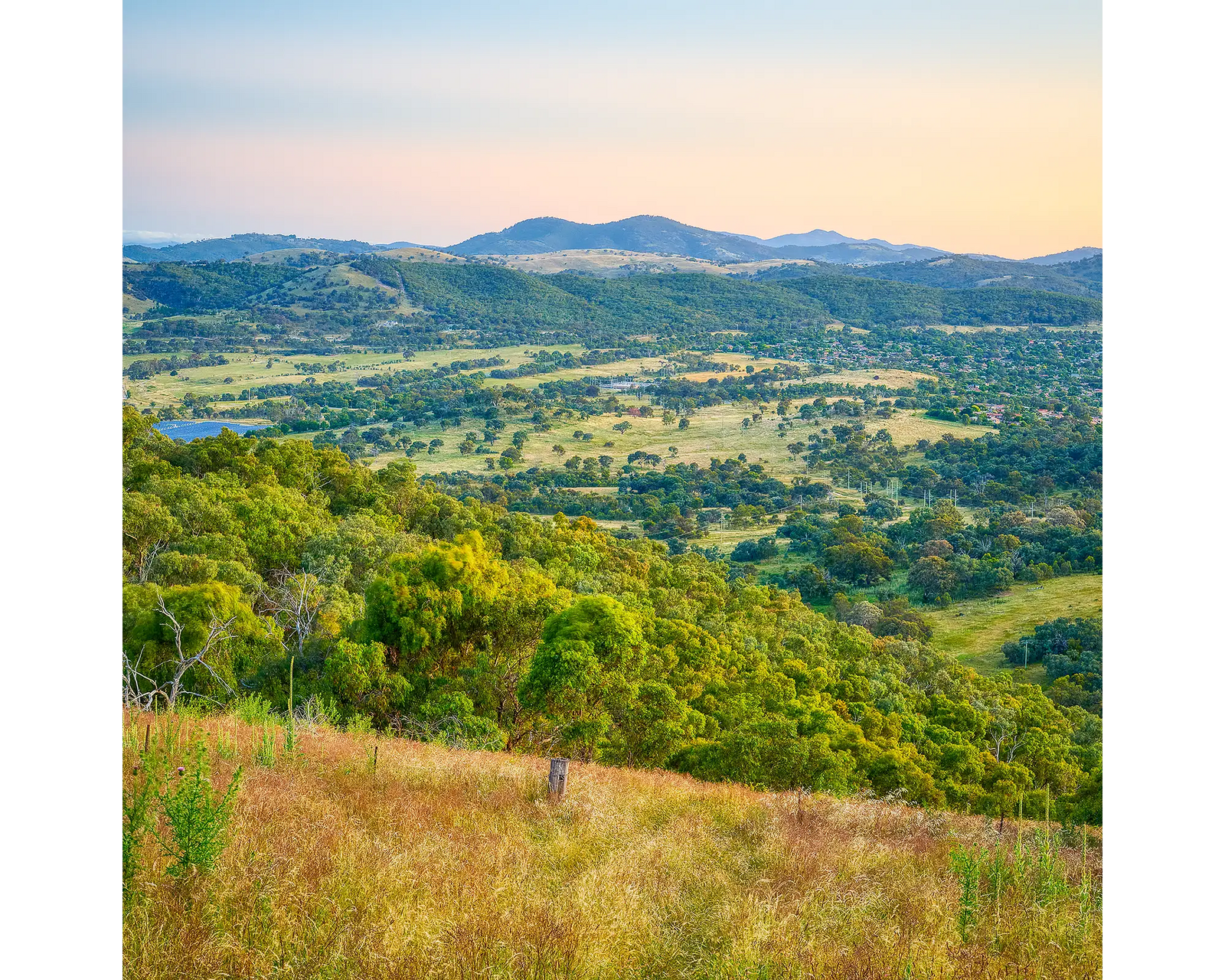 Isaacs Views. Scenic view of South Canberra with green hills and mountains under a clear sunset sky.
