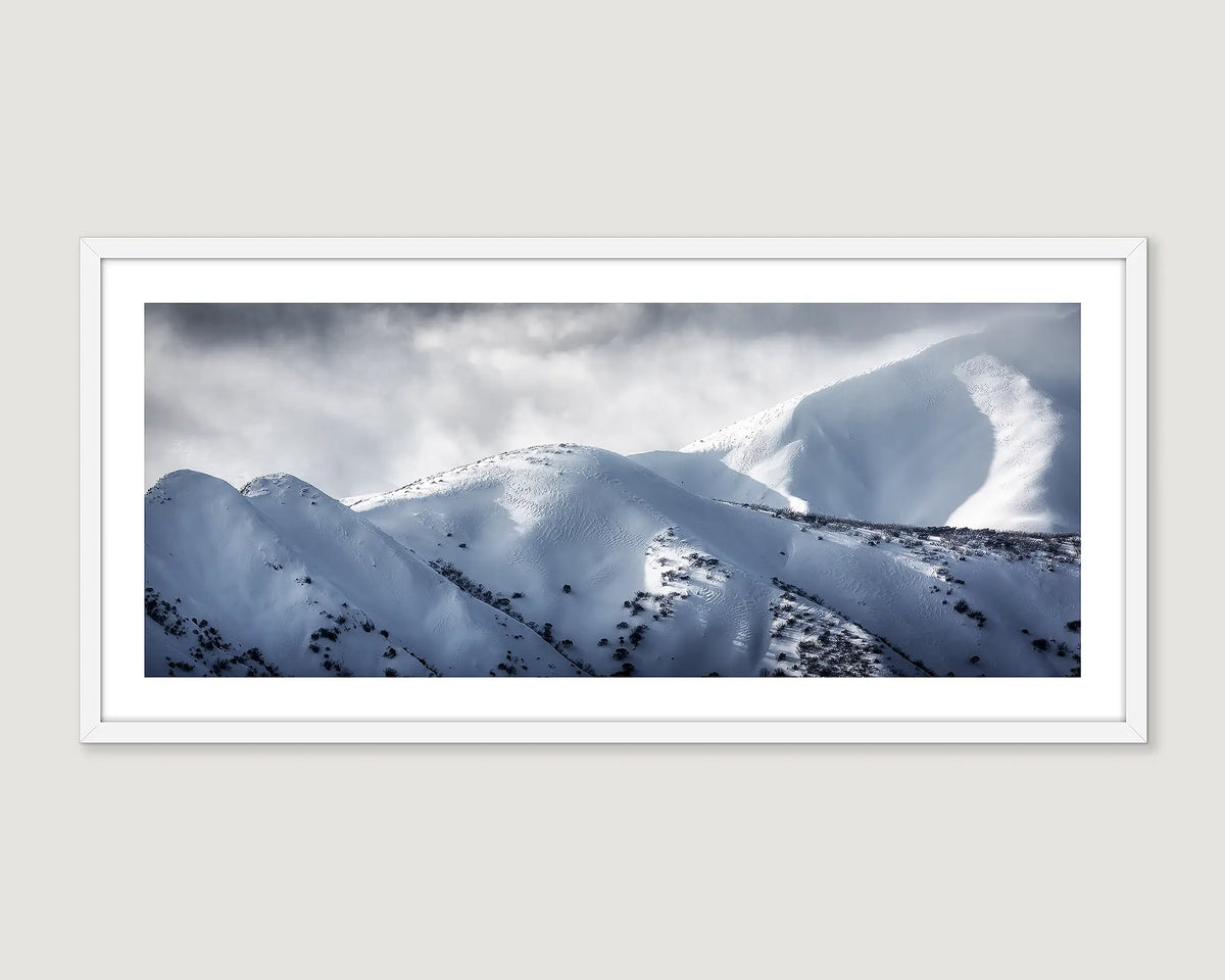 Framed wall art print of Mount Feathertop covered in snow with clouds. 