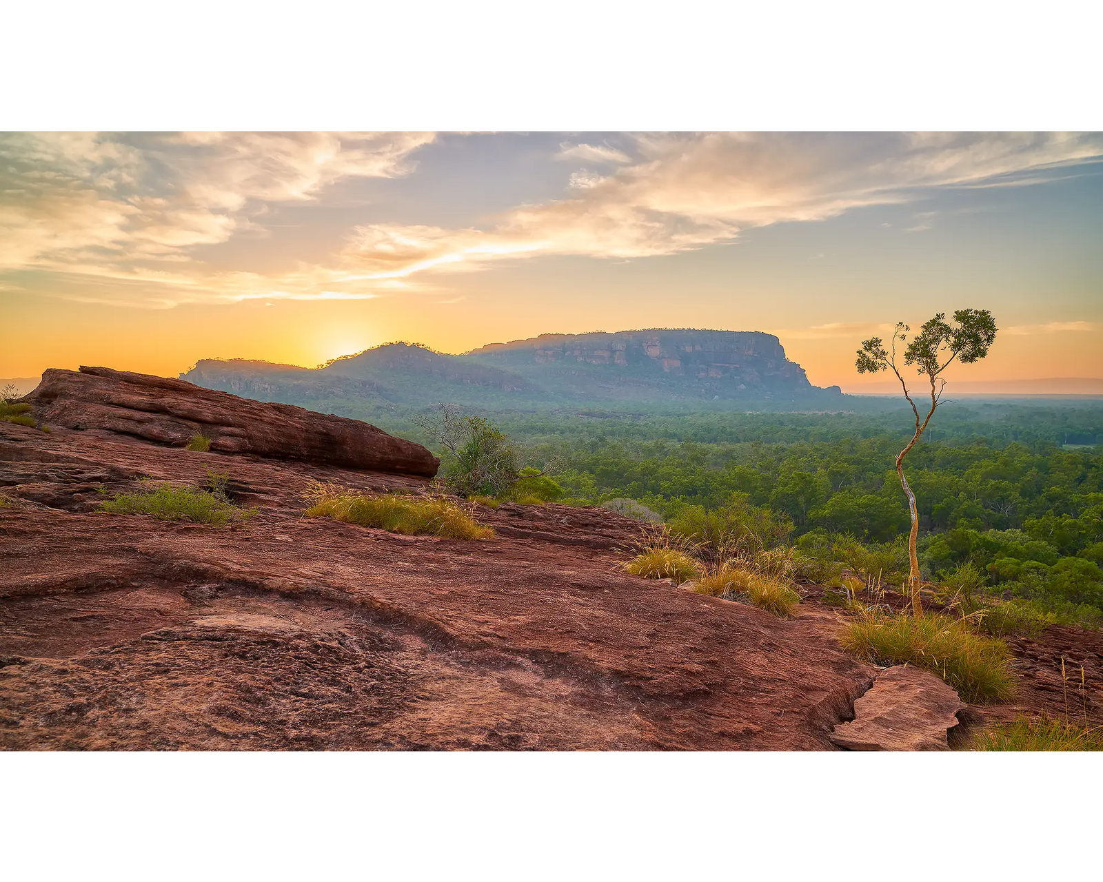 Framed photograph of rock formations and greenery at Kakadu at sunrise.