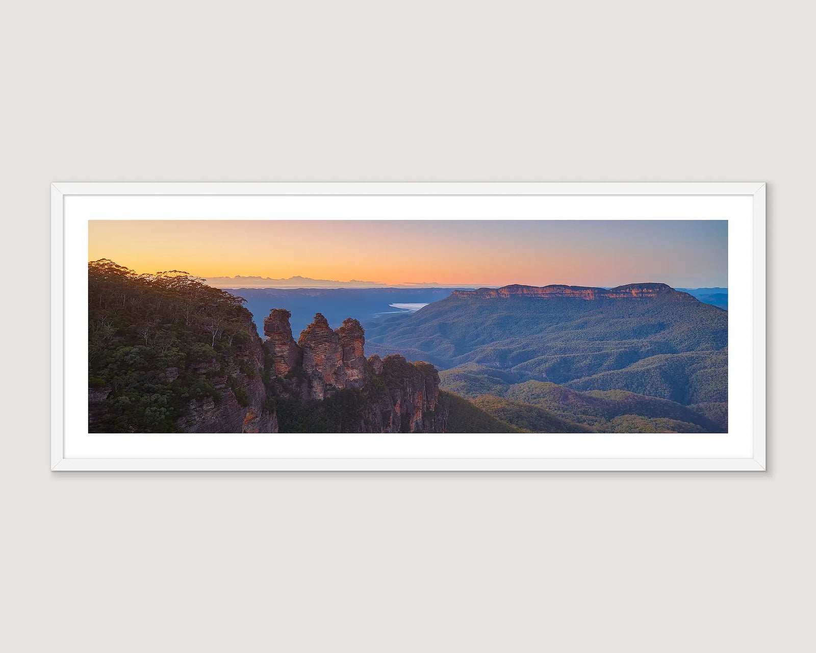 Framed photograph of rock formations and ranges and the three sisters at sunrise.