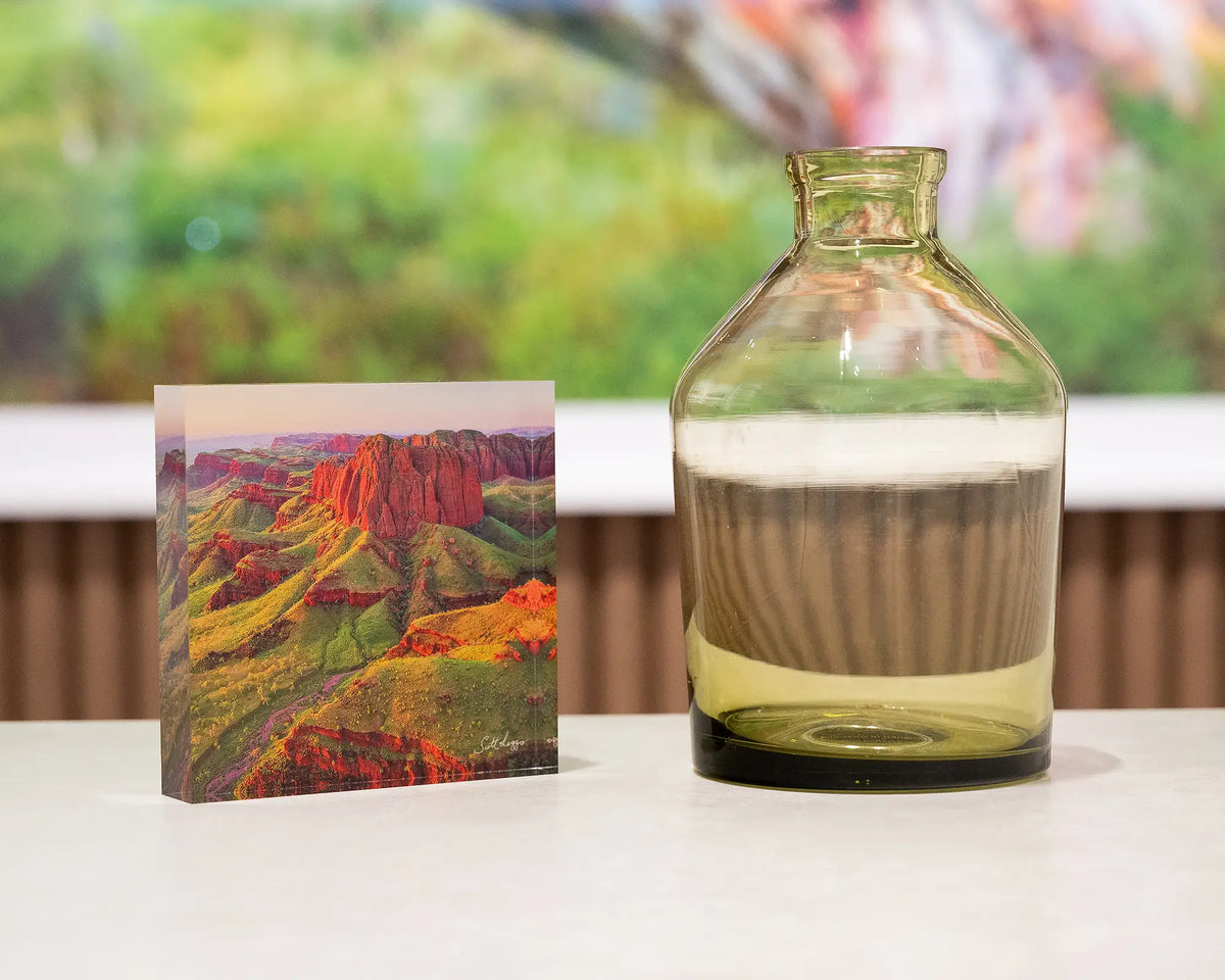 Kimberley Spirit. Acrylic block of Ragged Range, The Kimberley, styled with a small vase and Australian snow gum artwork in background.